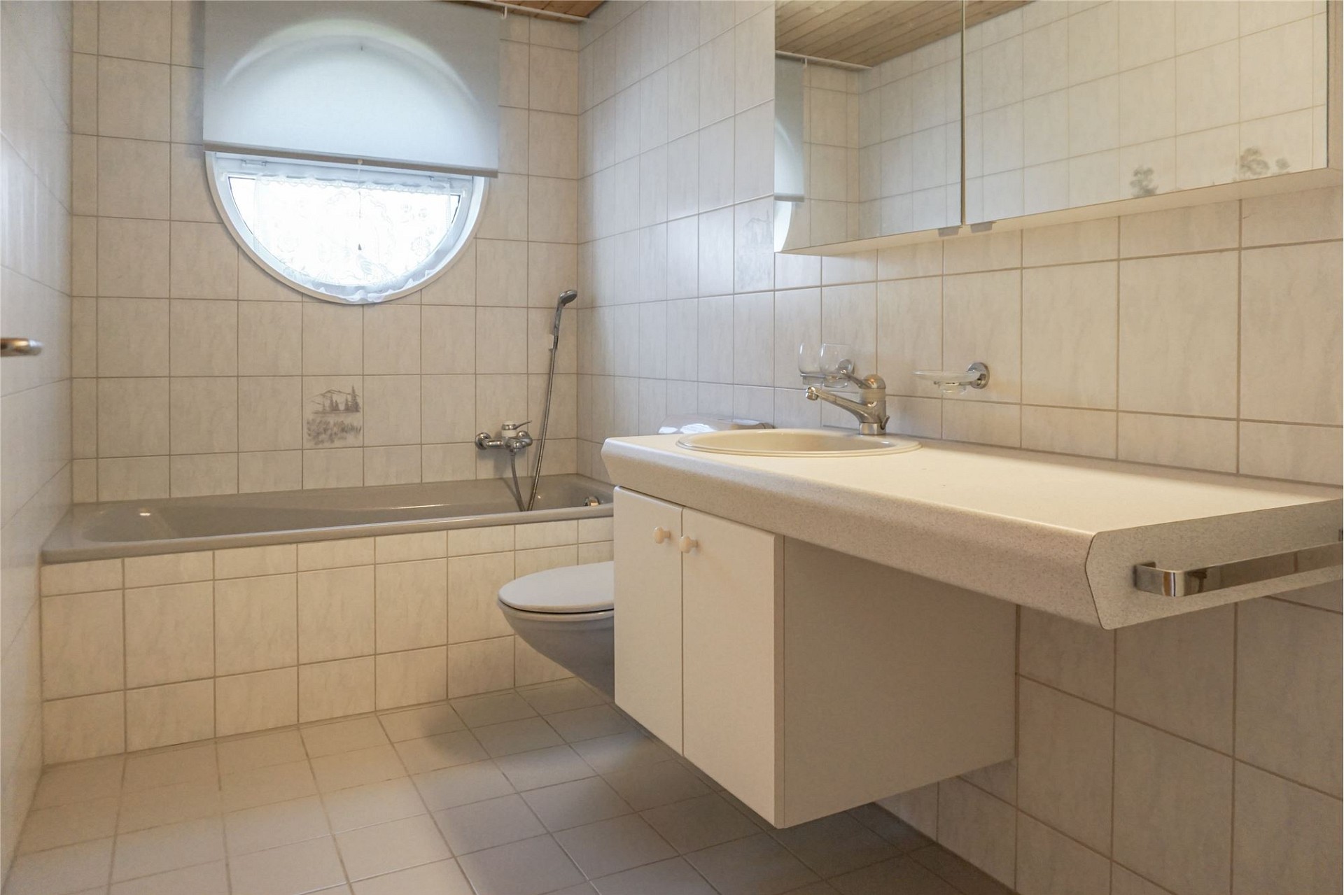 Kleines Badezimmer mit Badewanne und Waschtisch