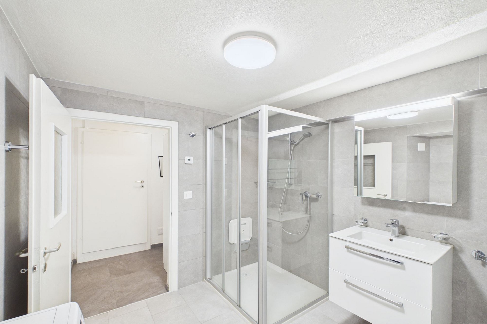 Modernes Badezimmer mit Duschkabine und Waschplatz
