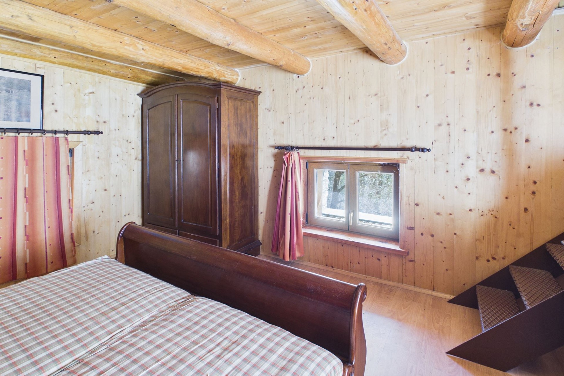 Rustikales Schlafzimmer mit Holzverkleidung