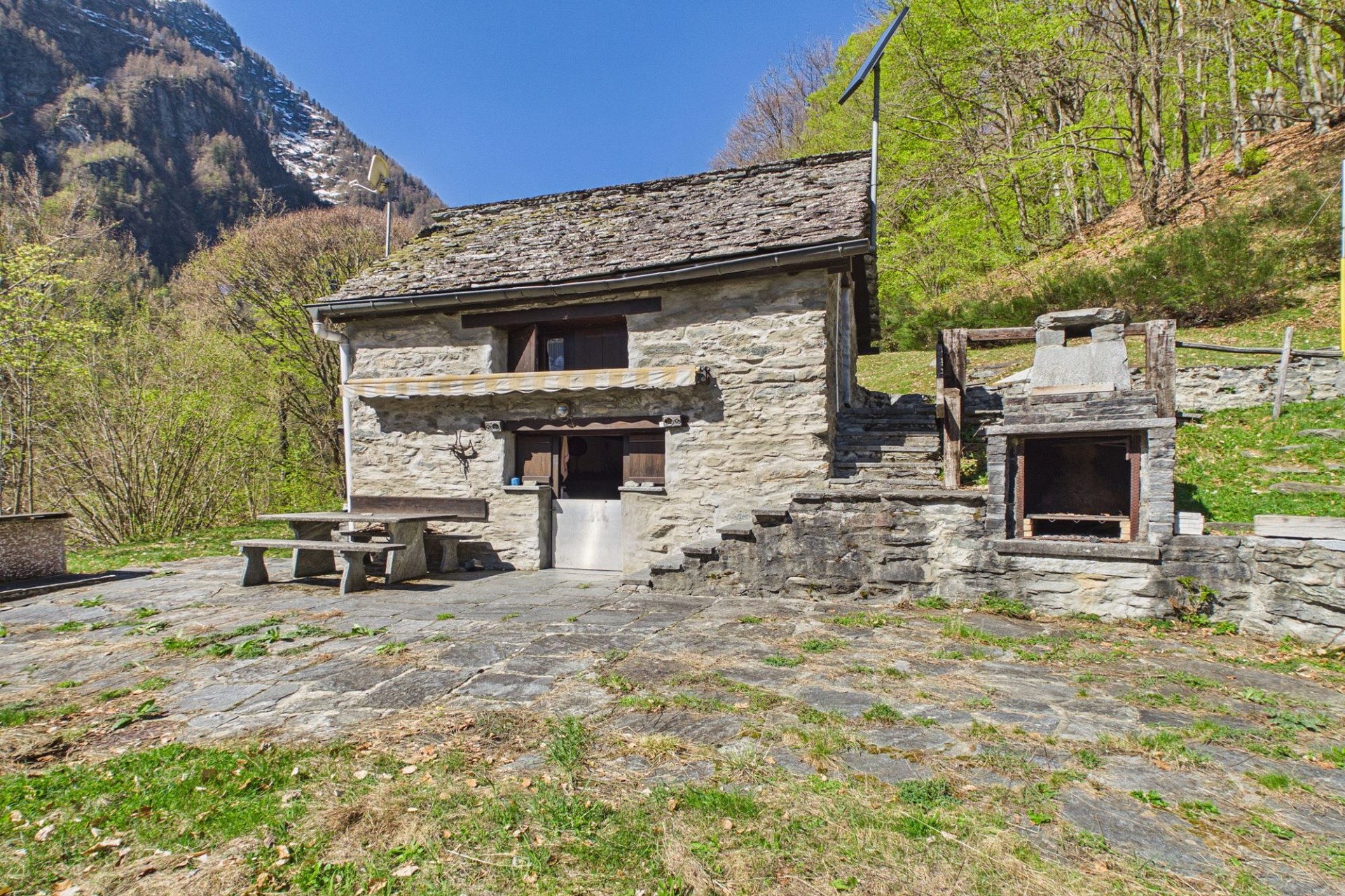 Steinhaus mit Bergkulisse und Außenbereich