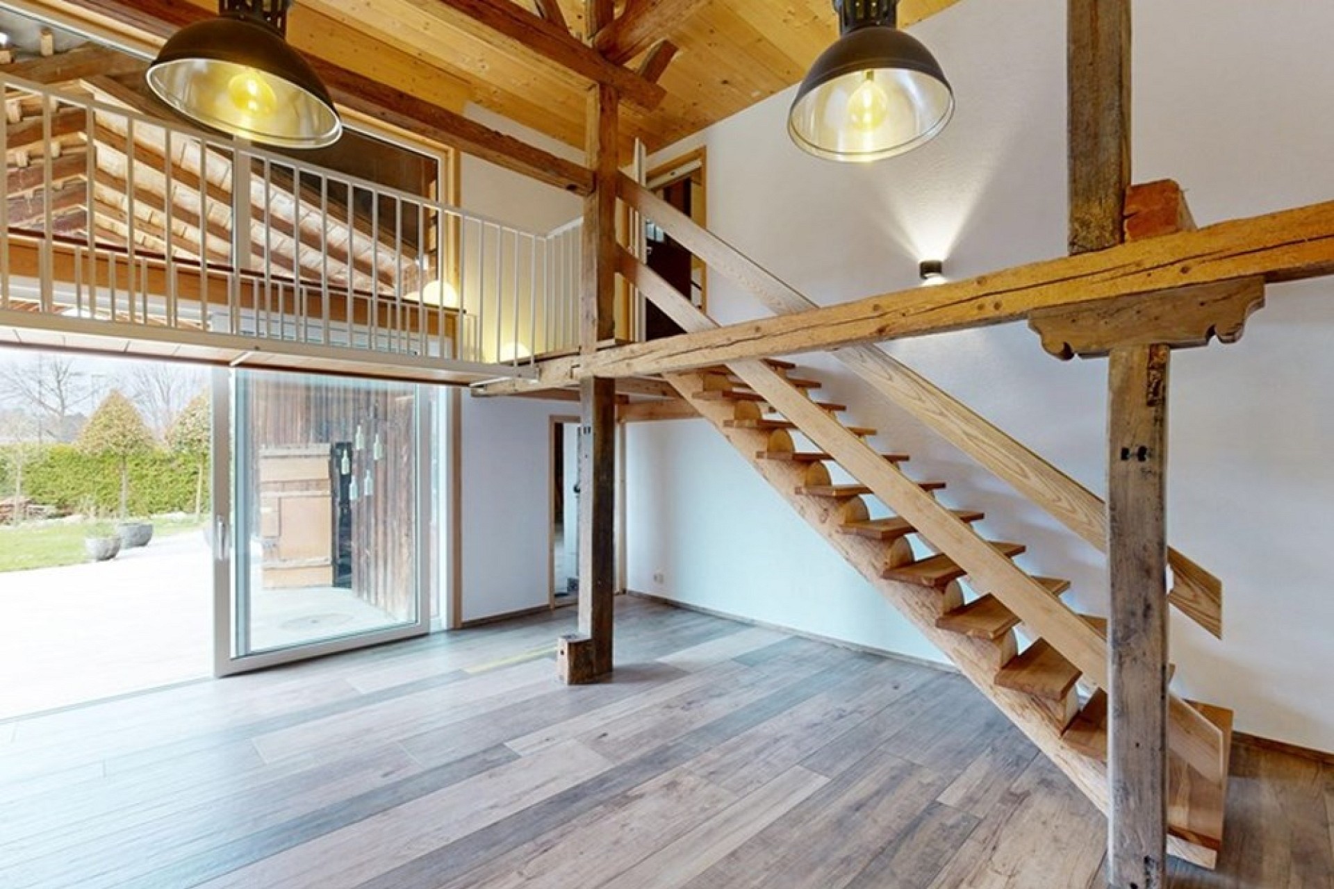 Lichtdurchfluteter Loftbereich mit offener Holztreppe