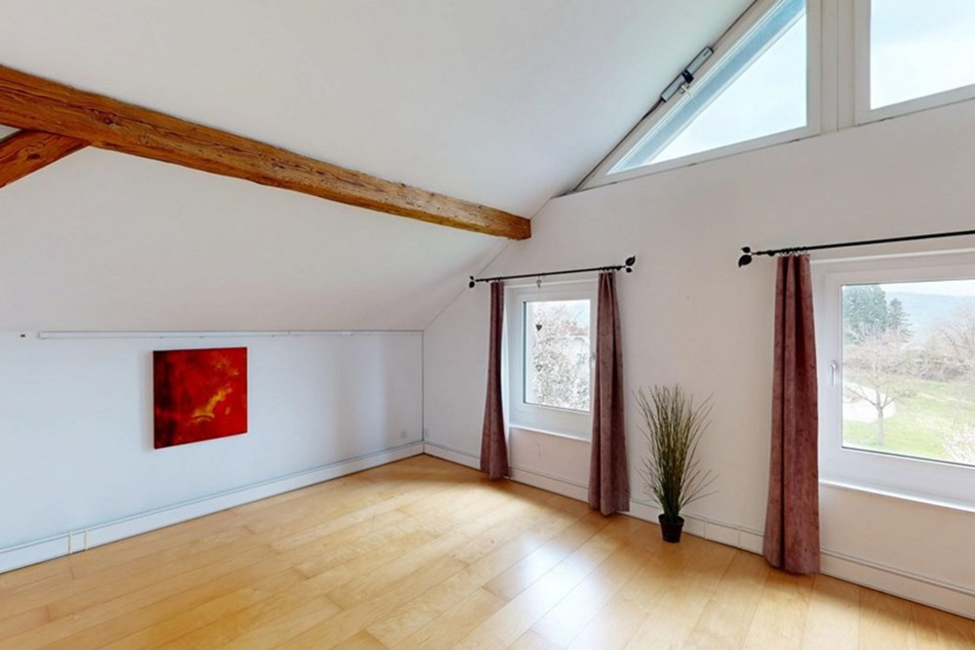 Heller Dachraum mit sichtbaren Holzbalken und Dachfenstern