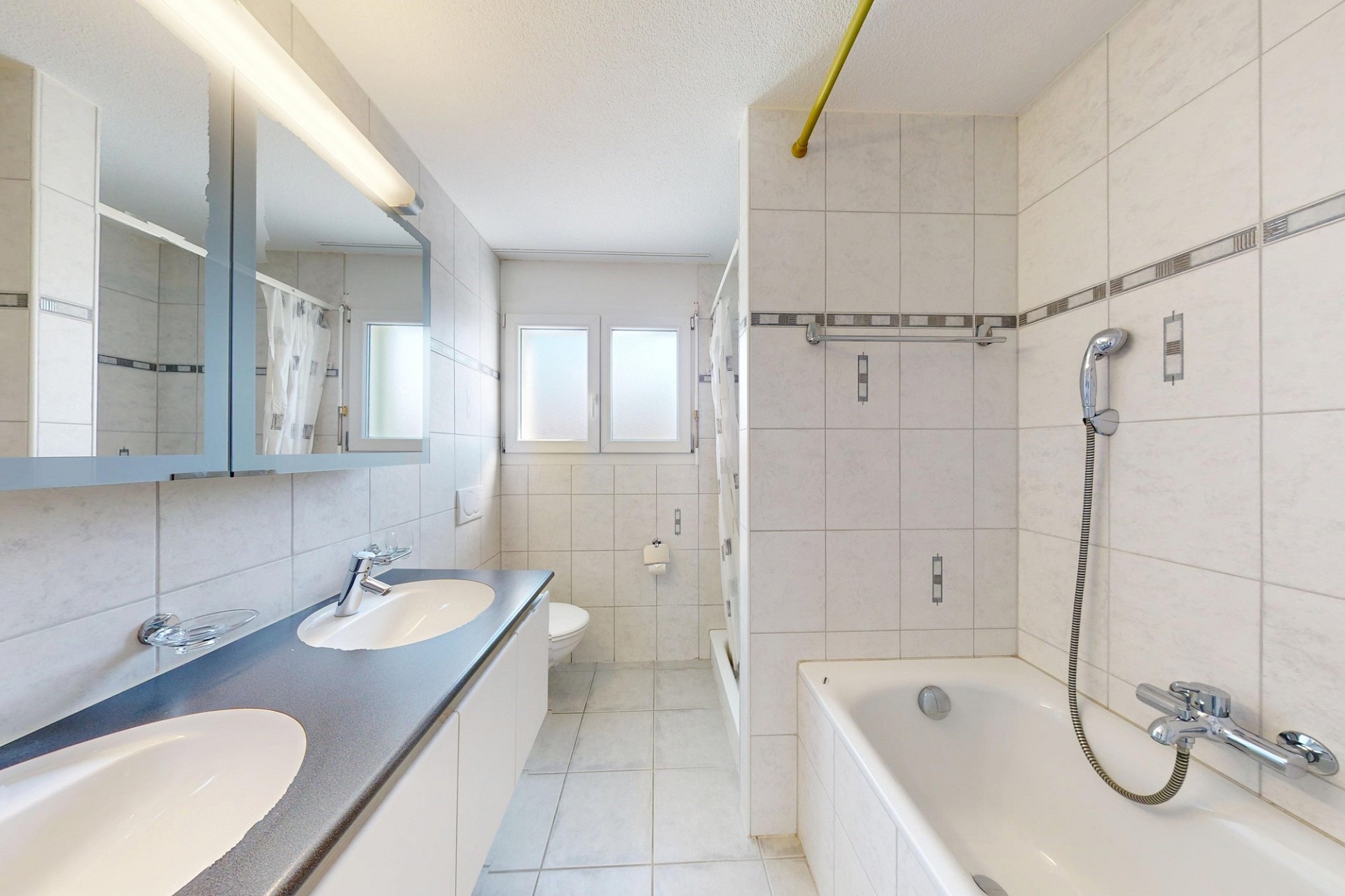 Helles Badezimmer mit Badewanne und Doppelwaschbecken