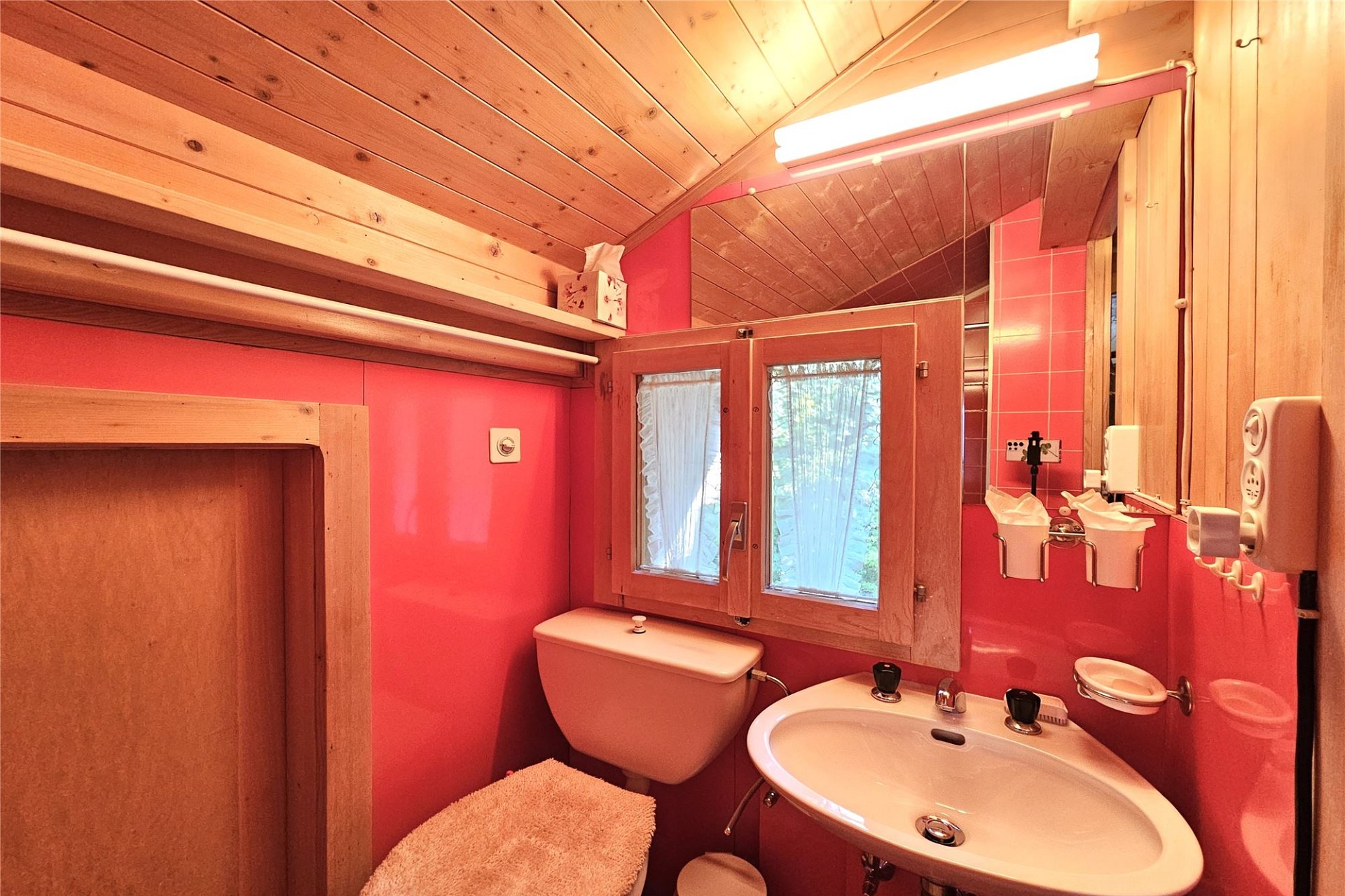 Kleines Badezimmer mit Holzverkleidung und pinken Wänden