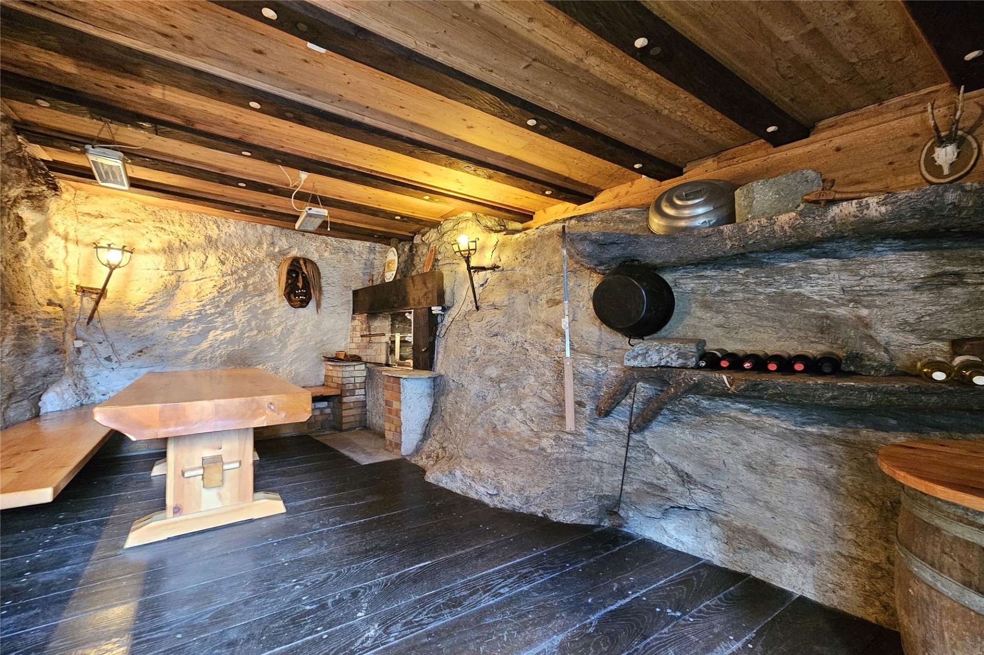 Rustikaler, höhlenartiger Innenraum mit Holzbalkendecke