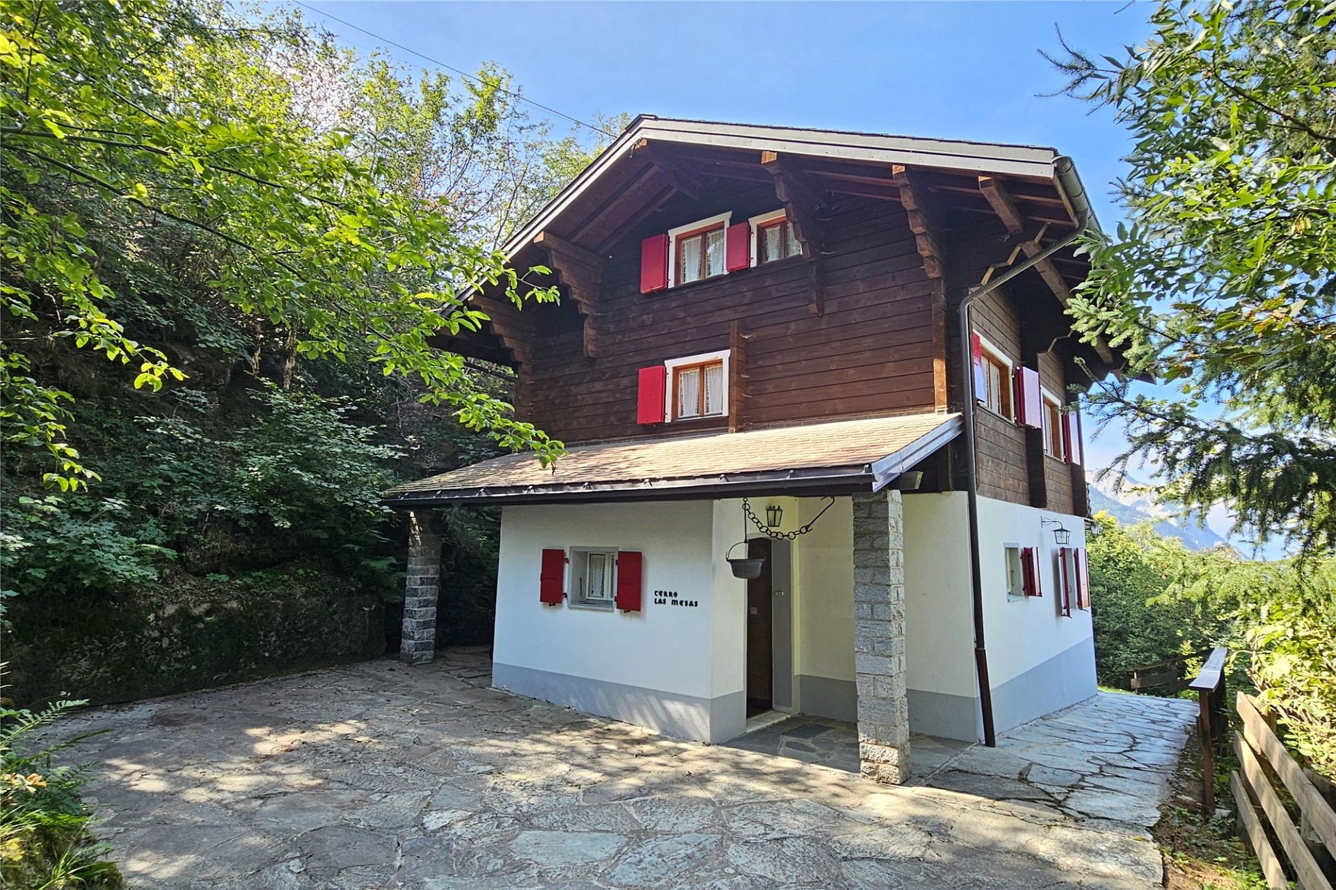 Alpenchalet mit Holzfassade und roten Fensterläden