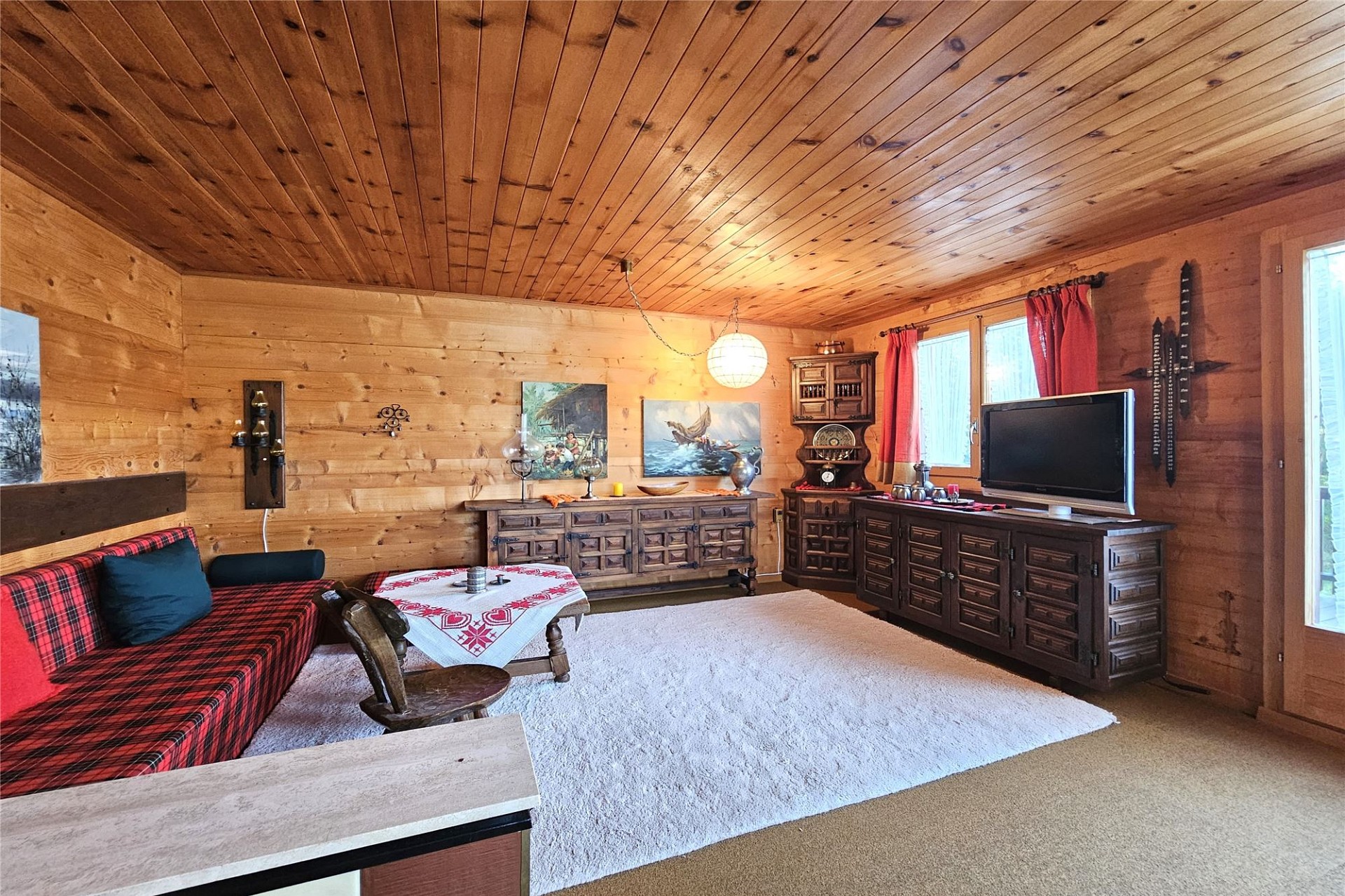 Rustikal eingerichtetes Wohnzimmer mit Holzvertäfelung