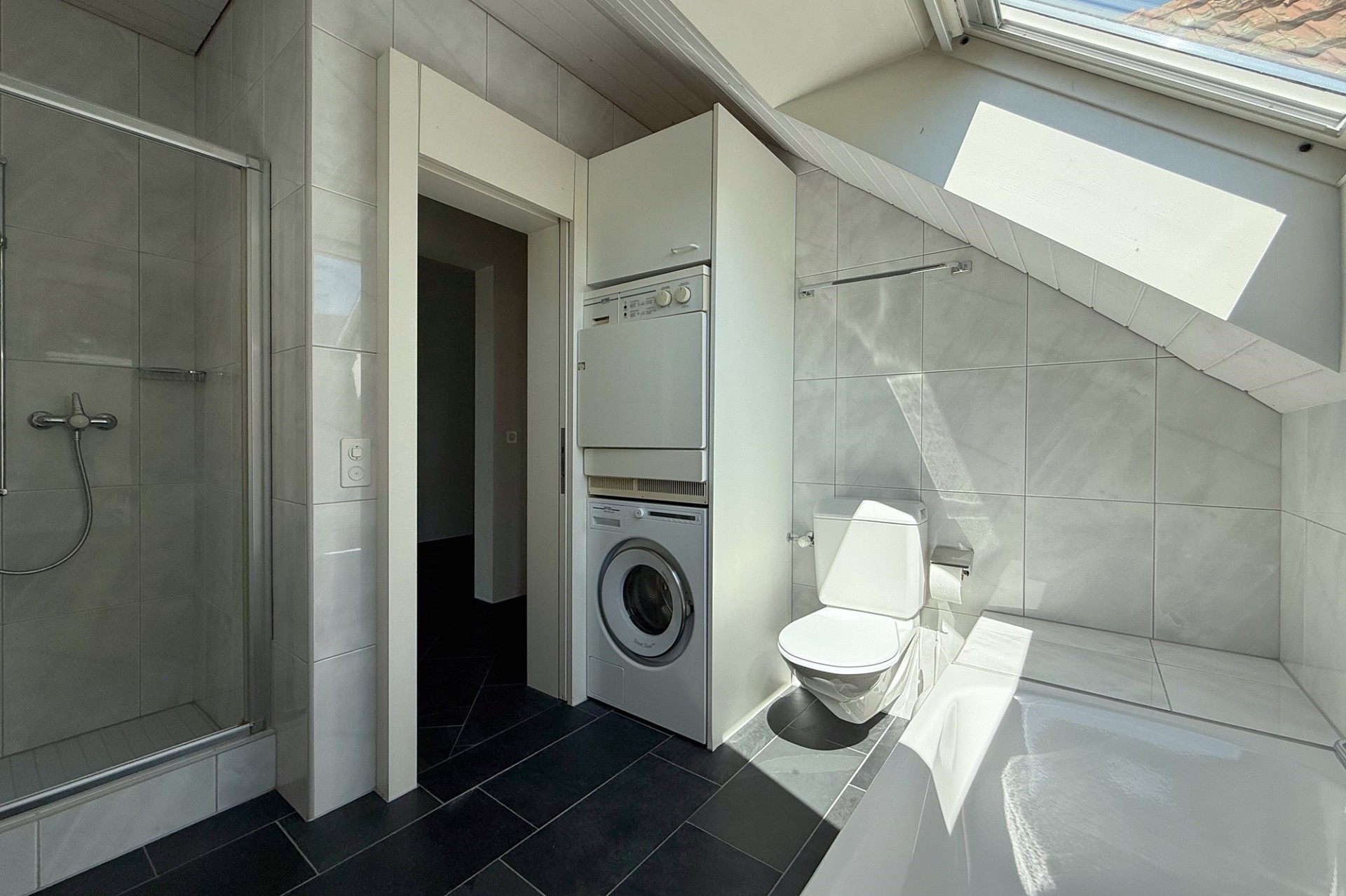 Helles Dachgeschossbad mit Dusche, WC und Waschmaschine
