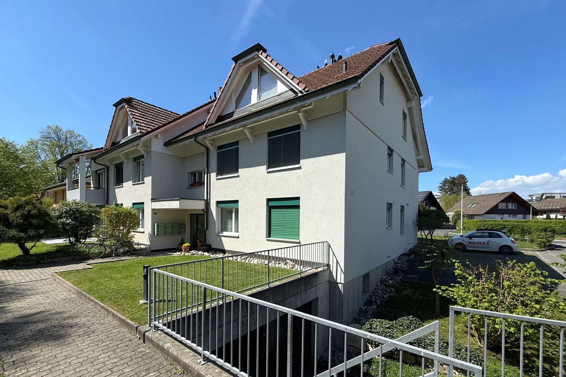 Mehrfamilienhaus mit Satteldächern und gepflegter Außenanlage