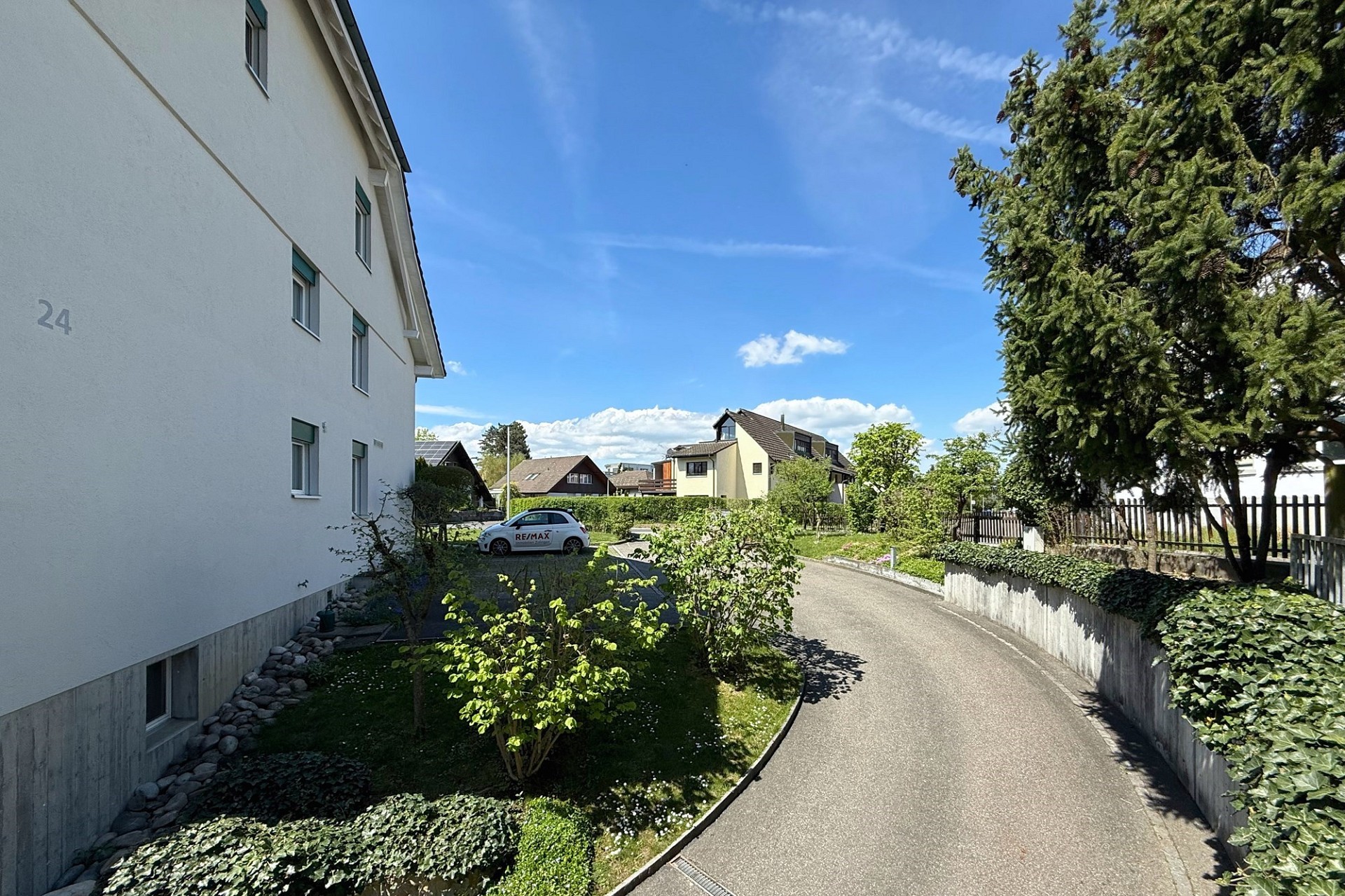 Wohnanlage mit Zufahrt und Gartenblick