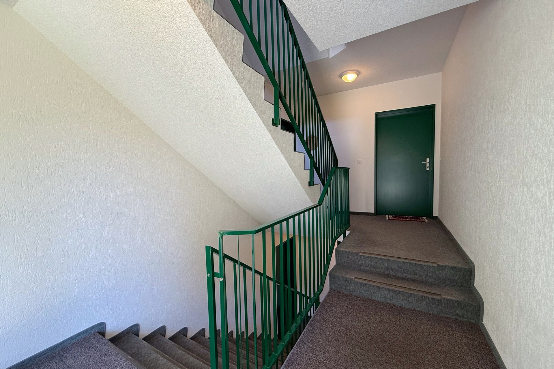Treppenhaus mit grünem Geländer