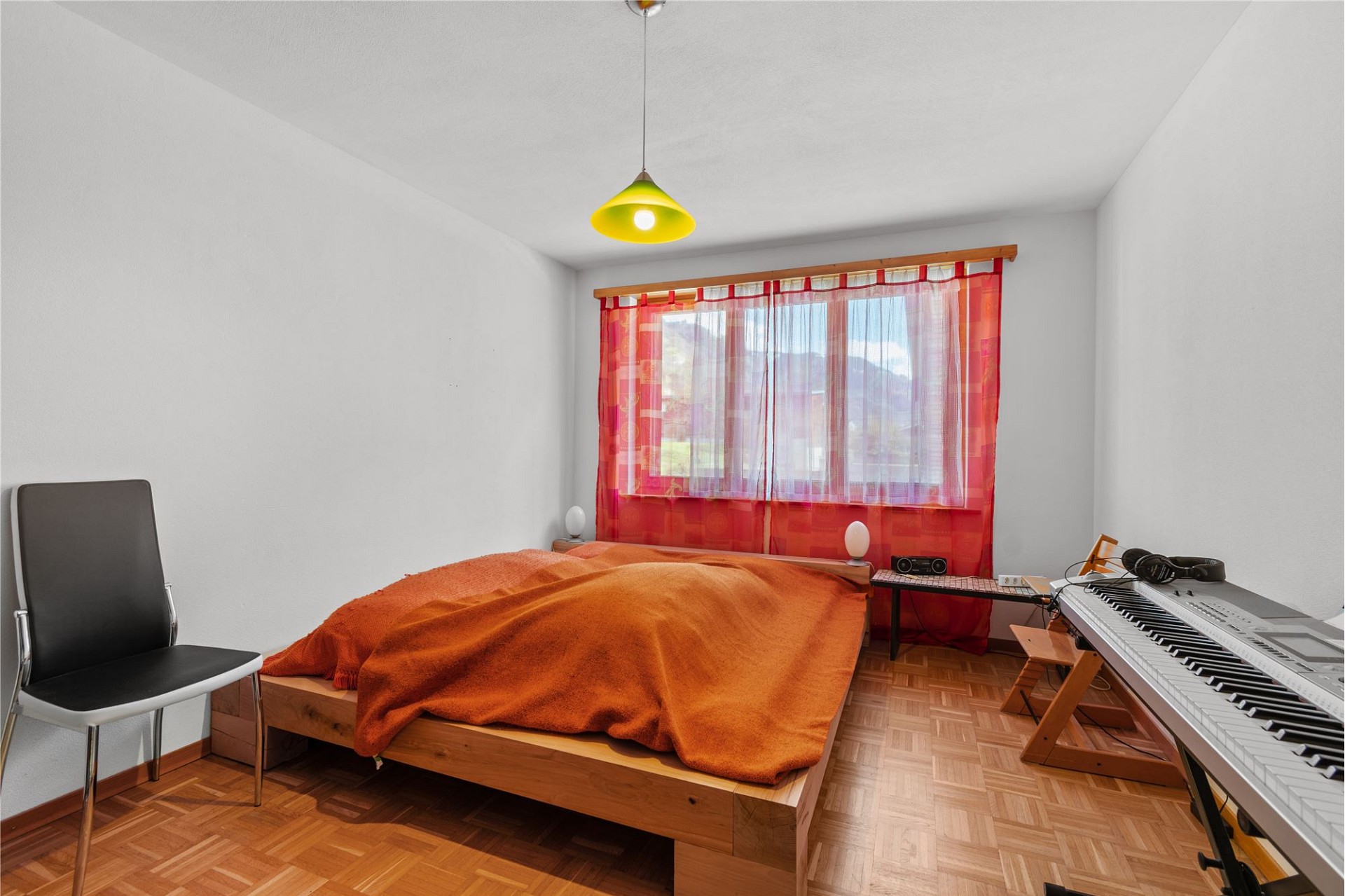 Schlafzimmer mit Bett, Fenster und Musikecke