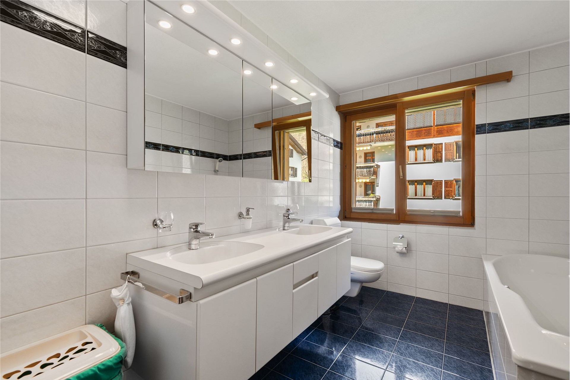 Helles Badezimmer mit Doppelwaschtisch und Wanne