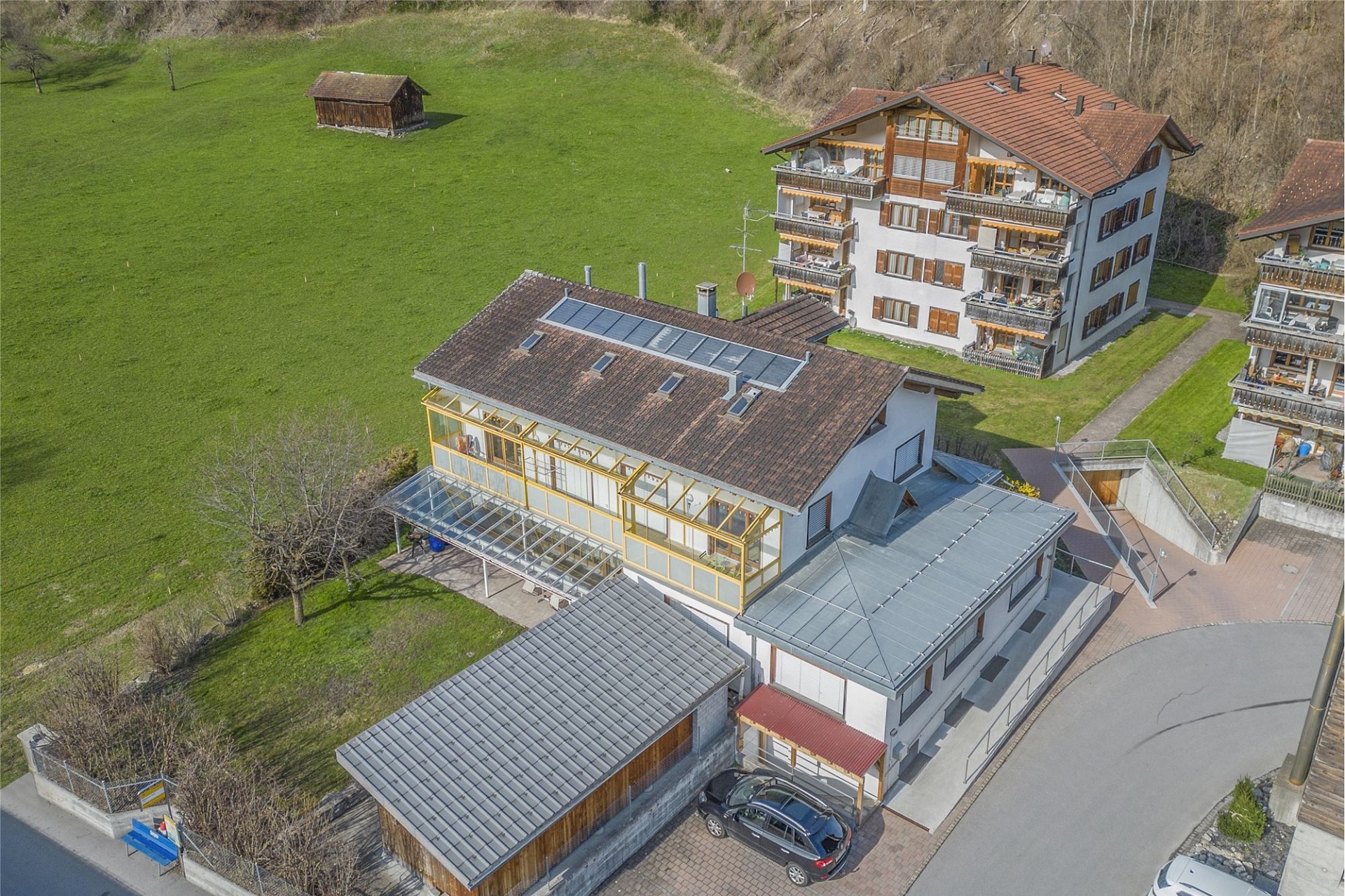 Luftaufnahme eines Wohngebäudes mit umliegender Grünfläche