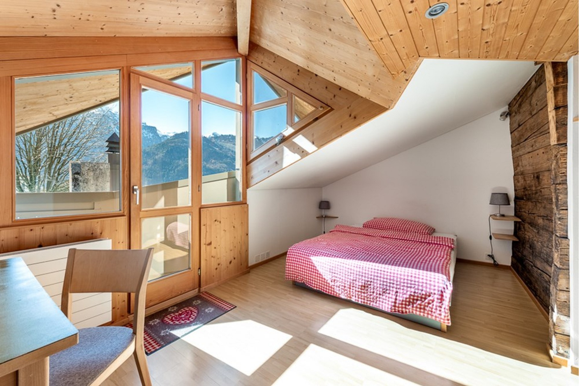 Helles Schlafzimmer mit Holzausbau und Bergblick
