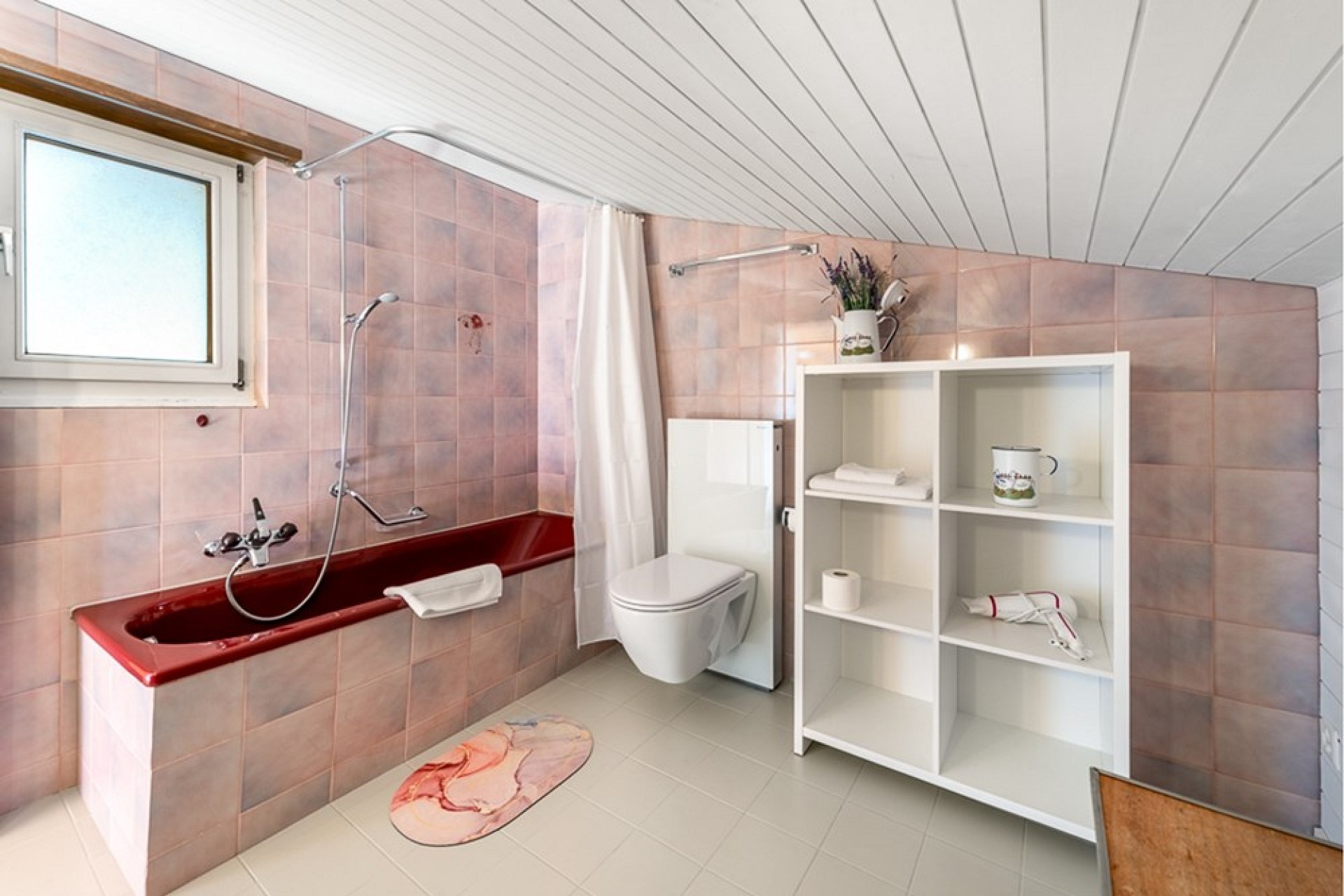 Badezimmer mit Badewanne und WC unter Dachschräge