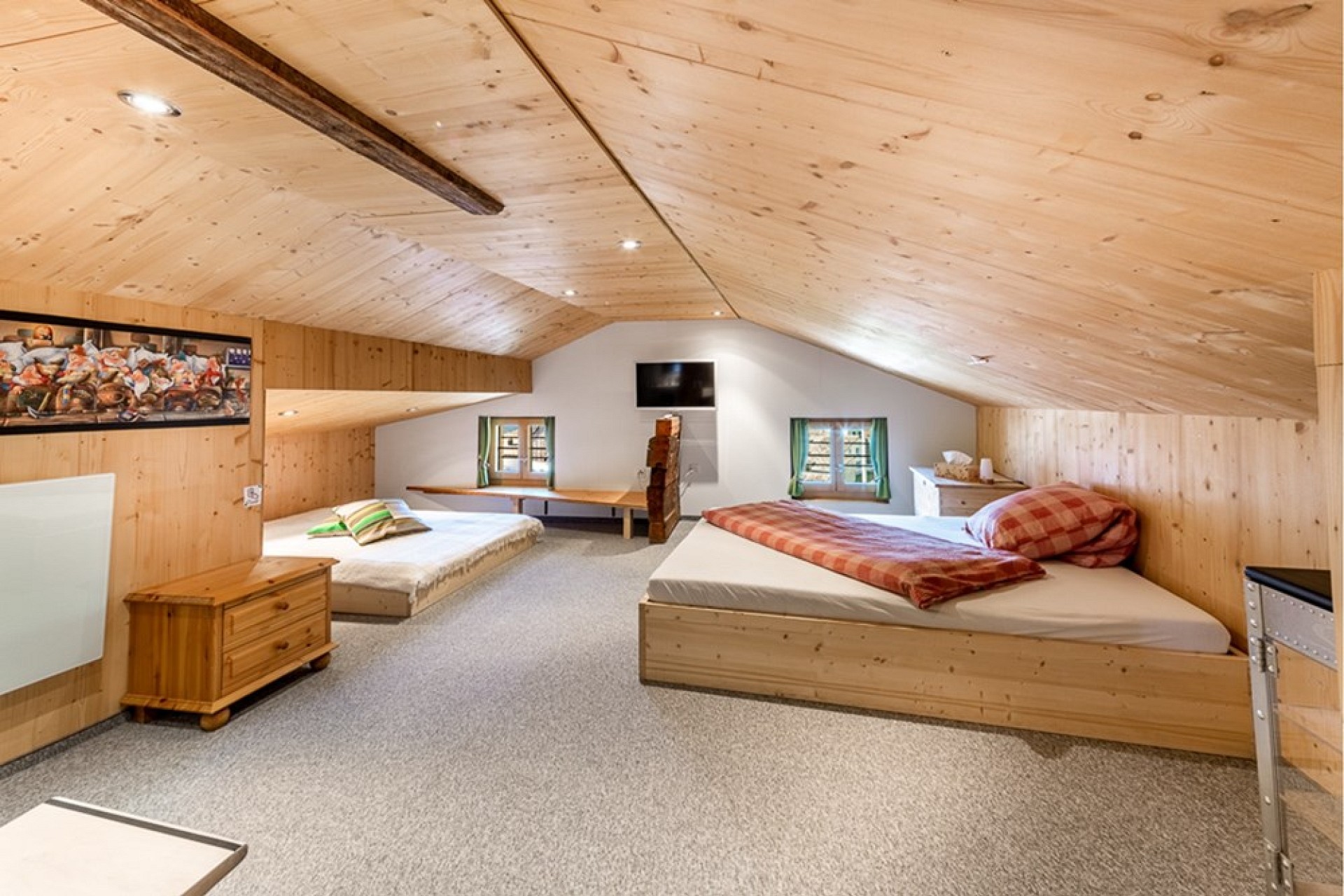 Dachzimmer mit Betten und Holzdecke