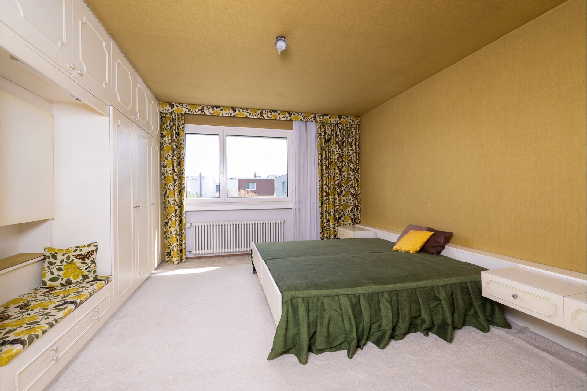 Schlafzimmer mit Einbauschrank und großem Fenster
