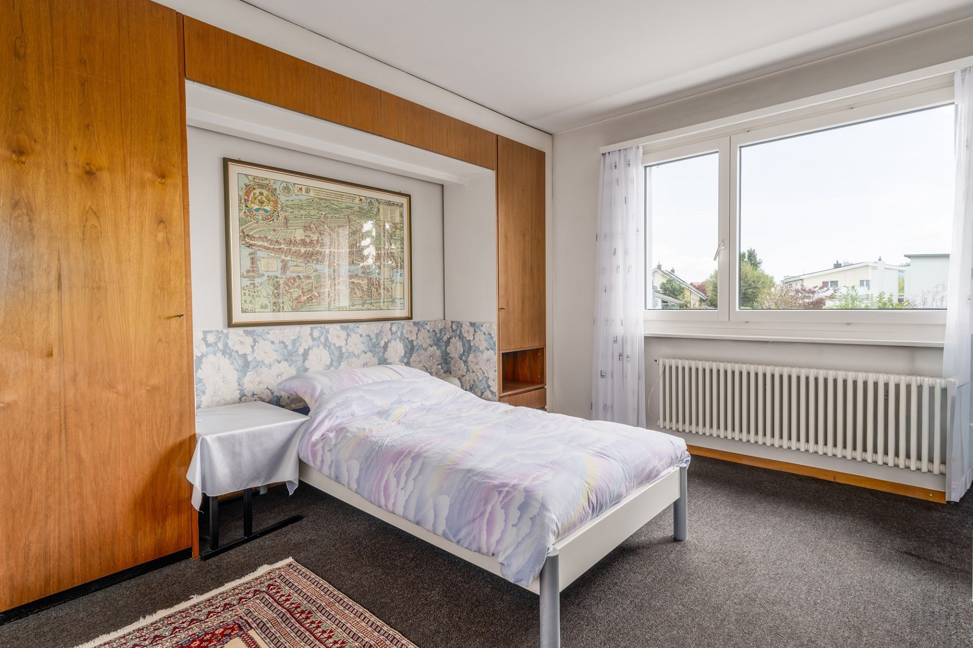 Schlafzimmer mit Einbauschrank und großem Fenster