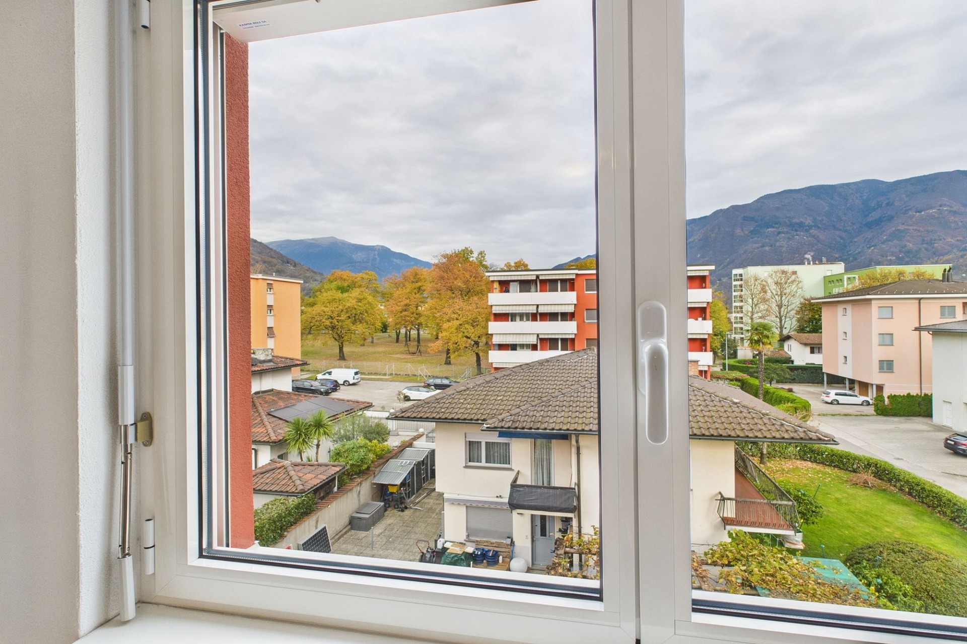 Blick aus dem Fenster auf Wohnhäuser und Berge