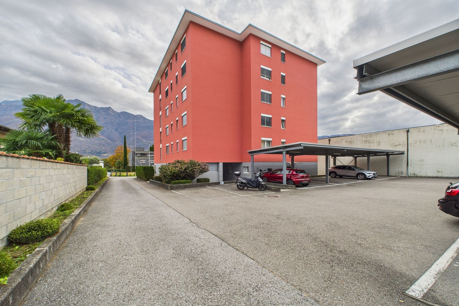 Wohnhaus mit Parkplatz und Bergkulisse