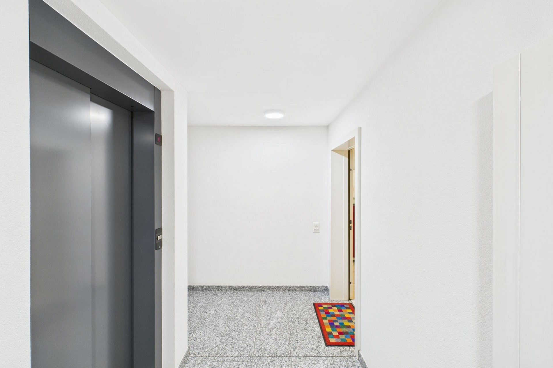 Moderner Hausflur mit Aufzug und Wohnungseingang