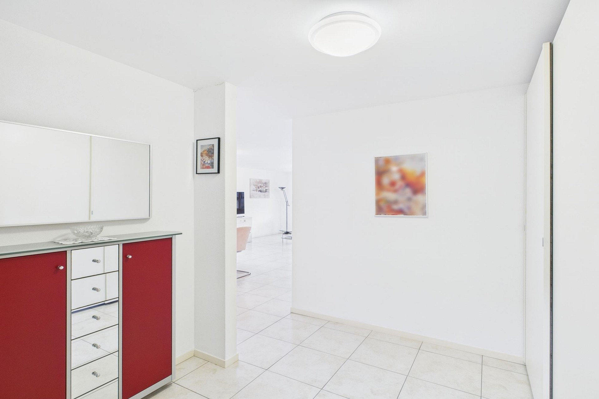 Heller Flur mit rotem Sideboard