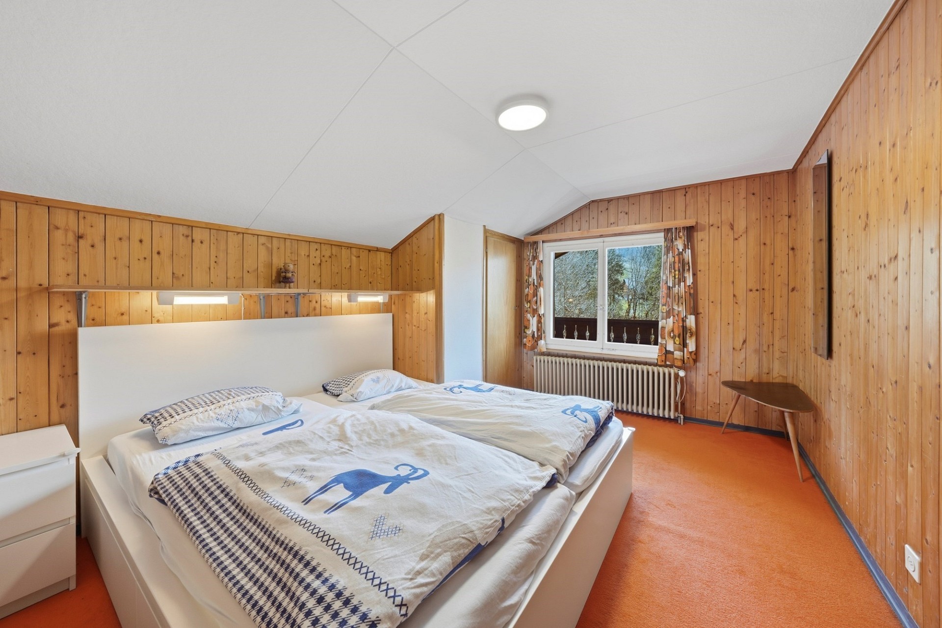 Gemütliches Schlafzimmer mit Holzverkleidung