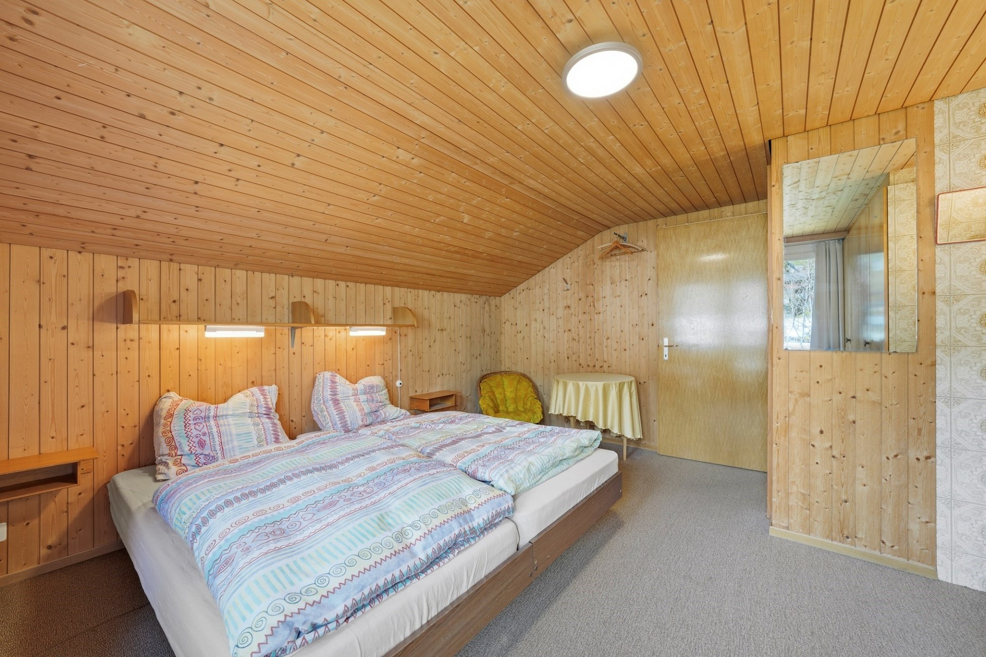 Gemütliches Schlafzimmer mit Holzverkleidung
