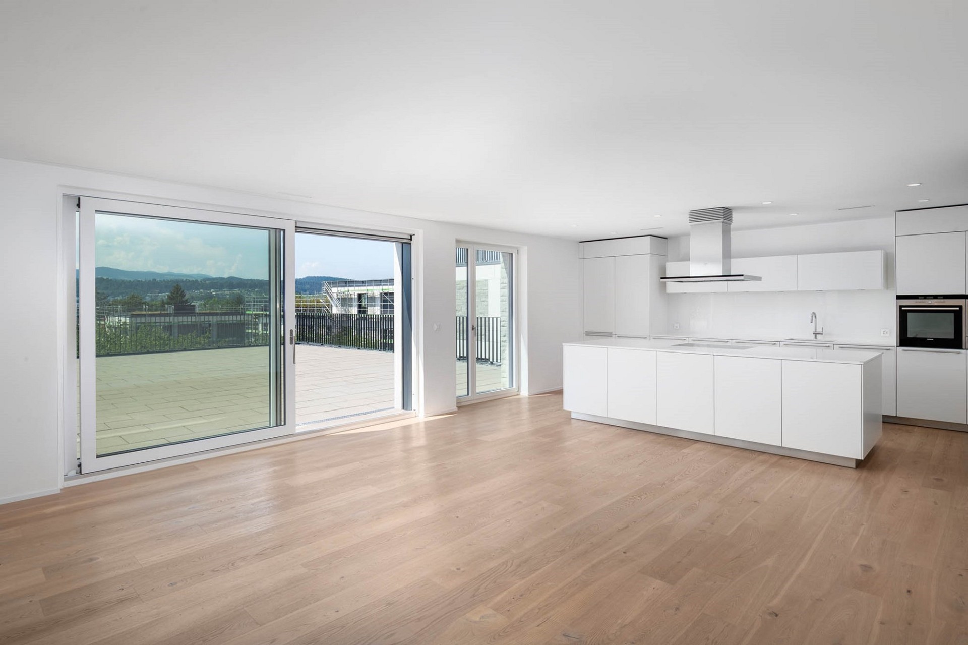 Offener Wohnbereich mit moderner Küche und großer Terrasse