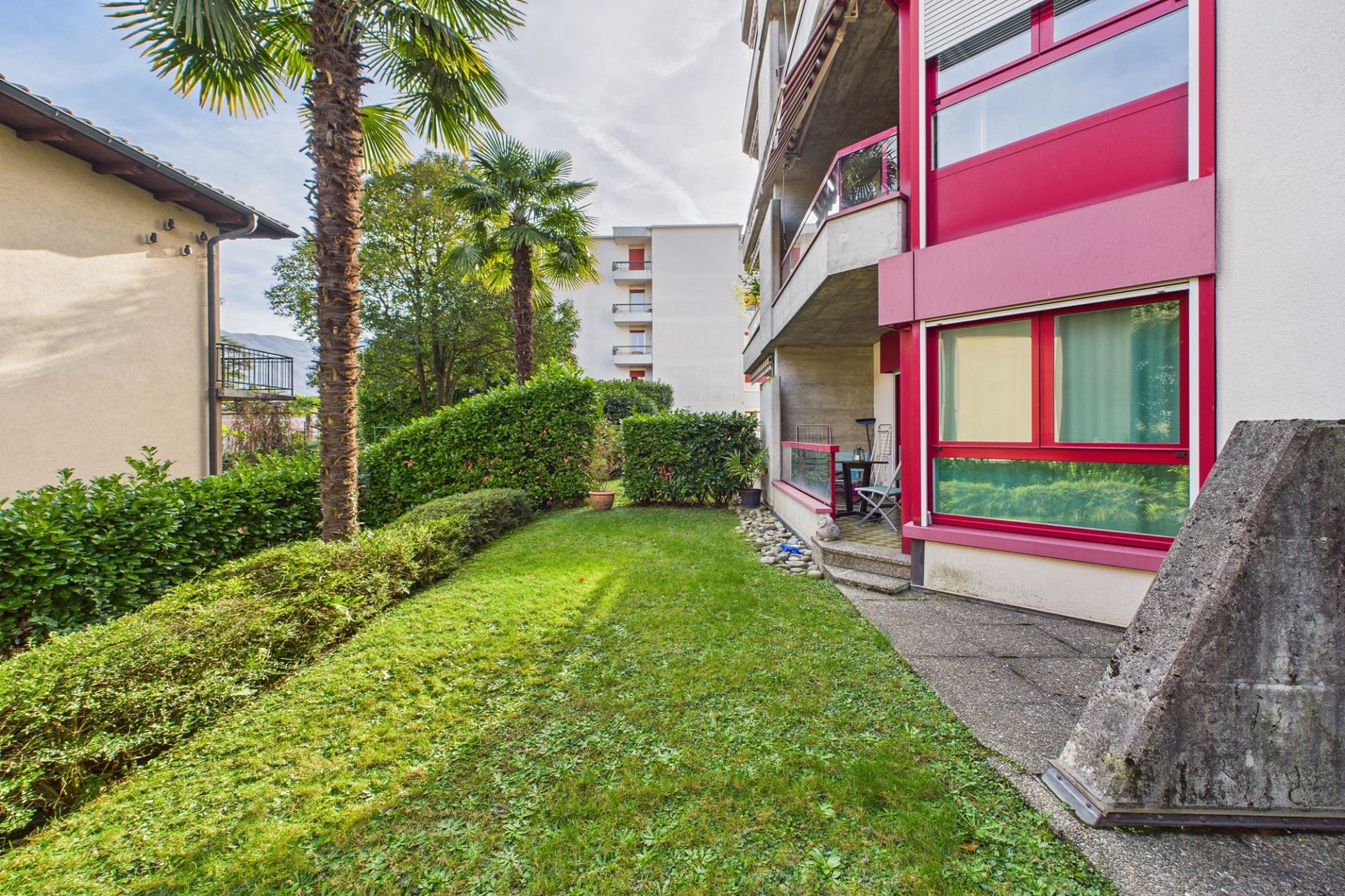 Gartenansicht eines Mehrfamilienhauses mit Balkon
