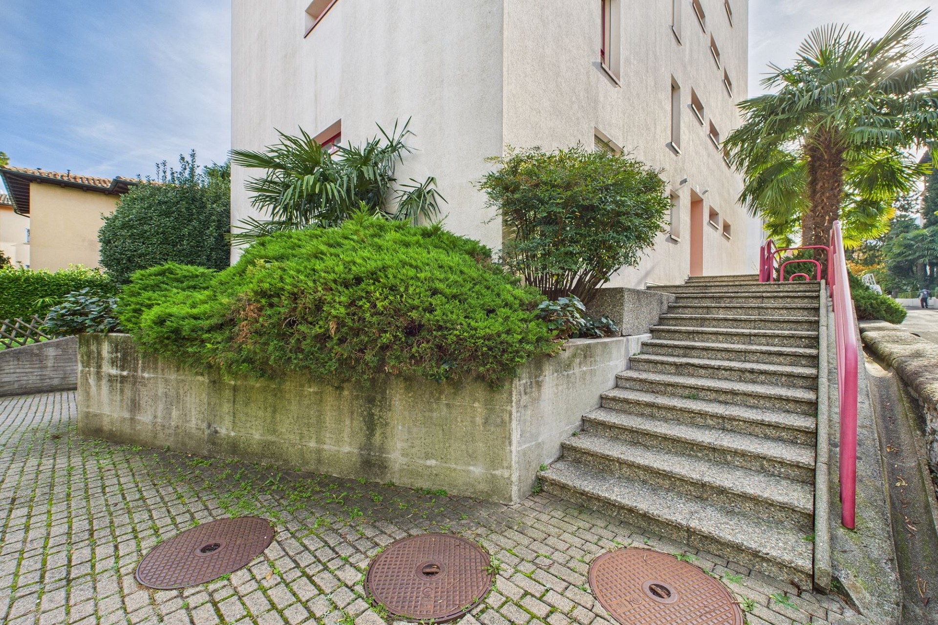 Außenansicht eines Wohngebäudes mit Treppe und Begrünung