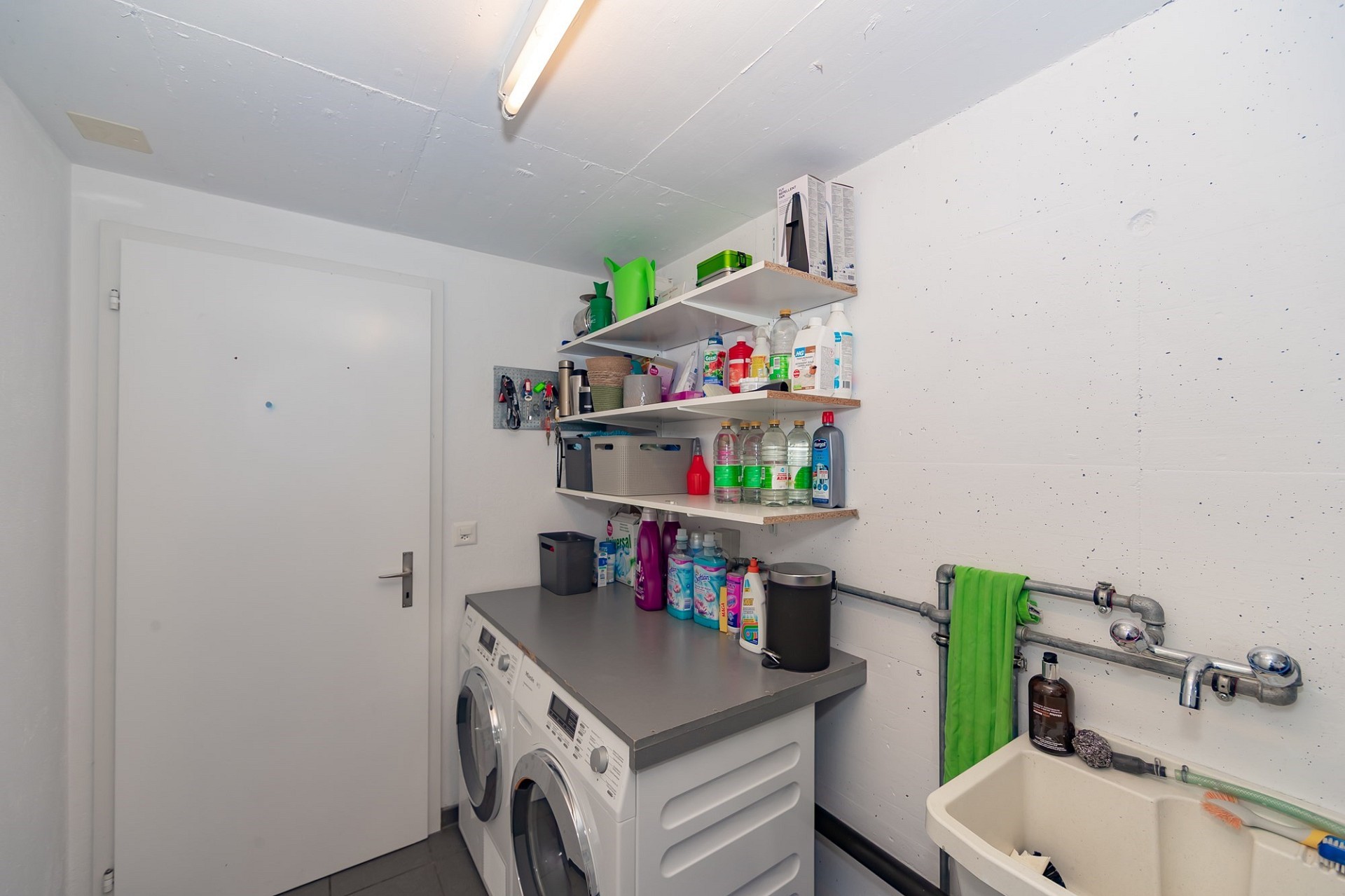 Hauswirtschaftsraum mit Waschmaschine und Waschbecken