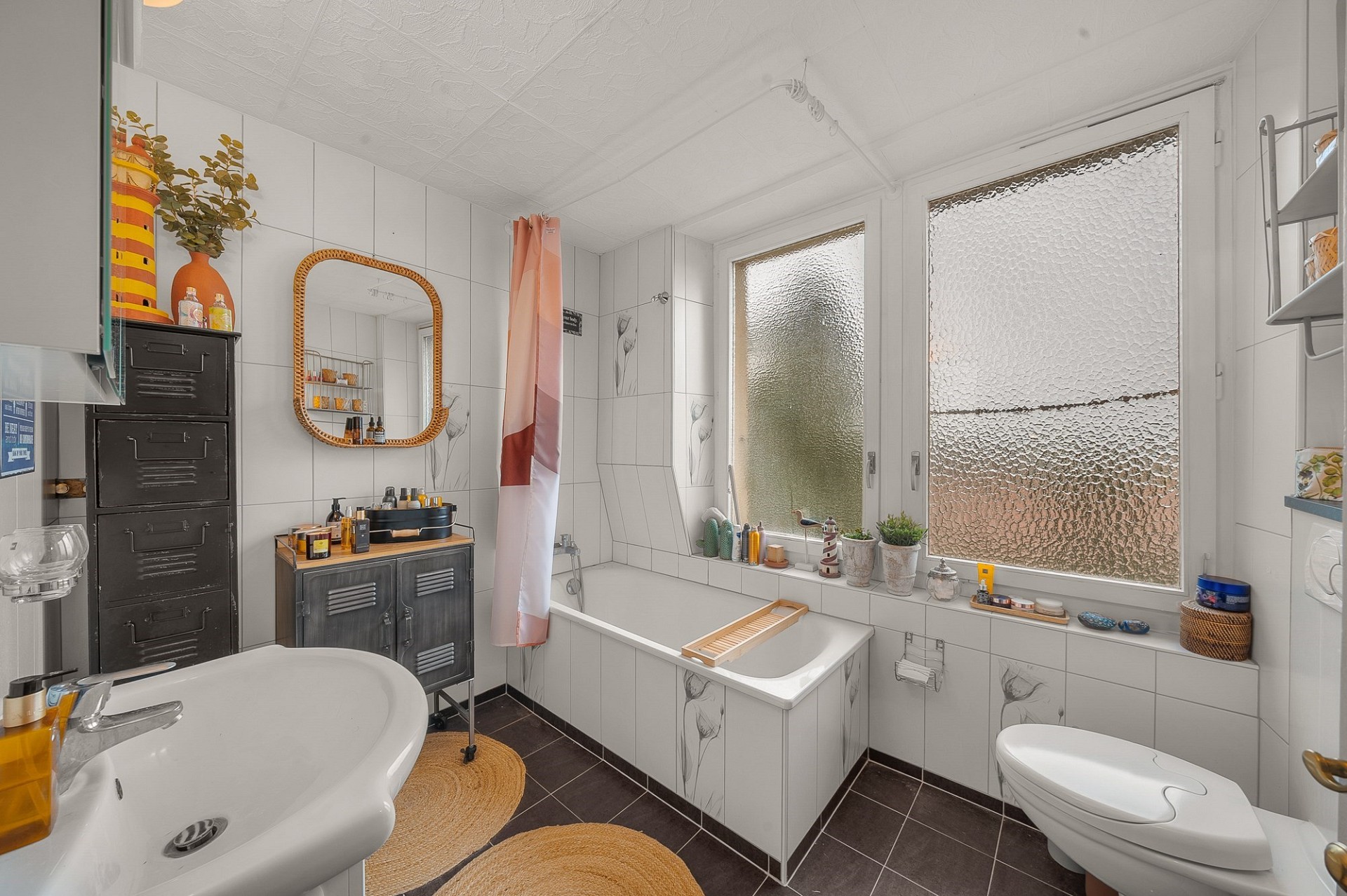 Helles Badezimmer mit Badewanne und großen Milchglasfenstern
