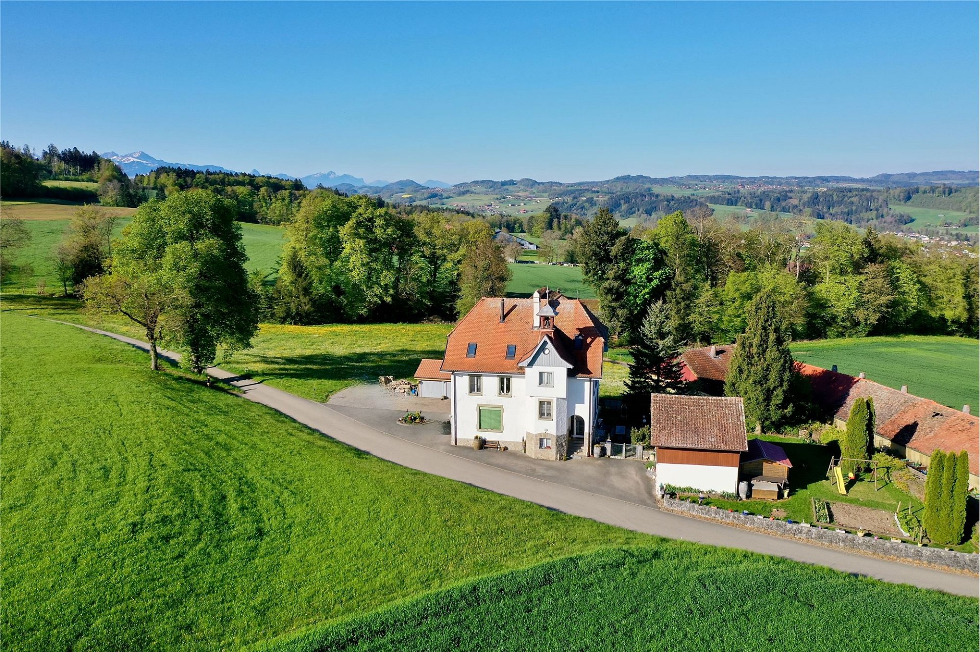 Luftaufnahme eines ländlichen Anwesens mit Ausblick ins Grüne
