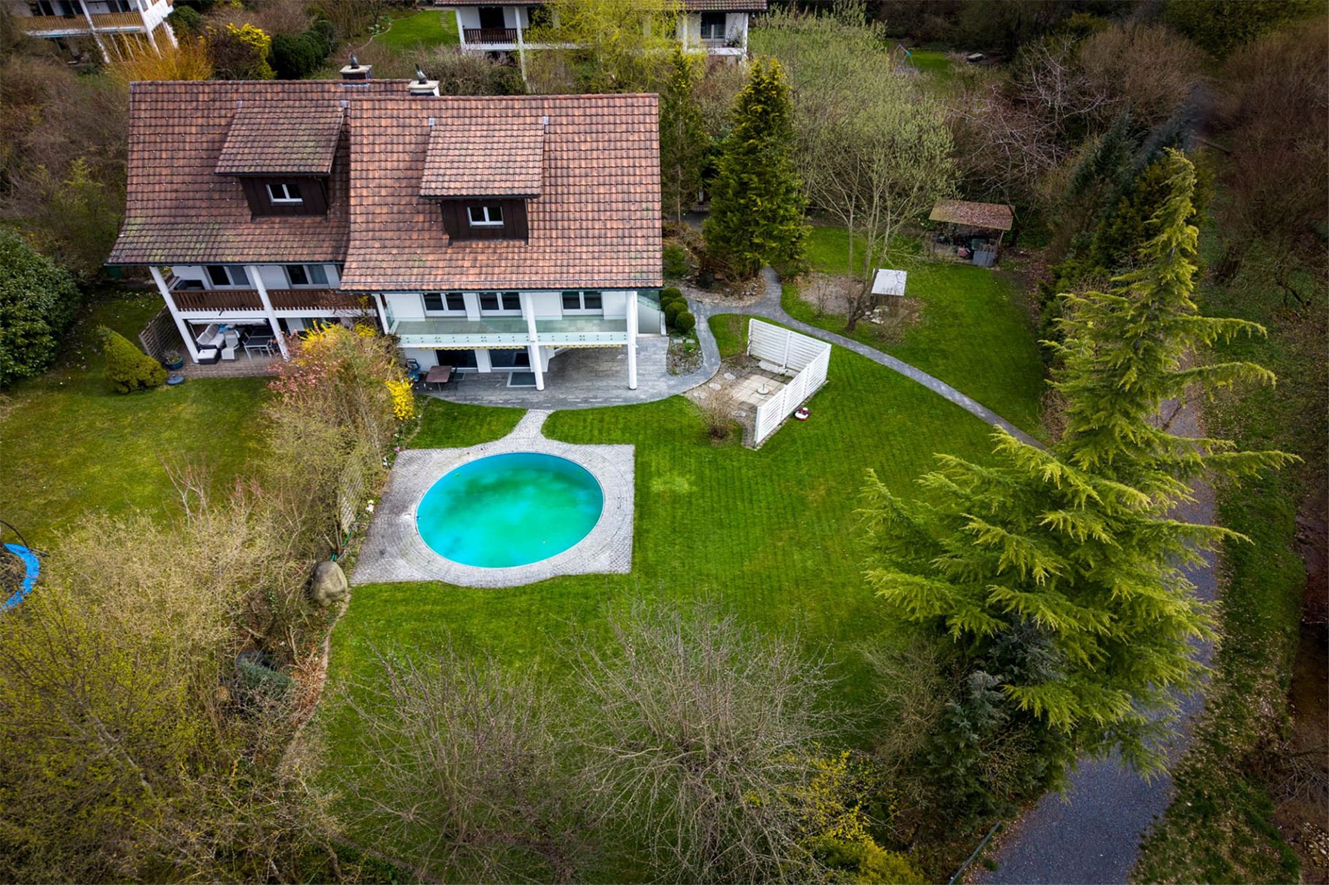 Luftaufnahme eines Hauses mit Garten und Pool