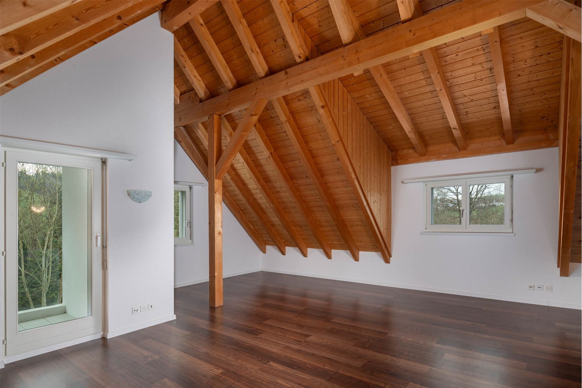 Dachgeschossraum mit sichtbaren Holzbalken