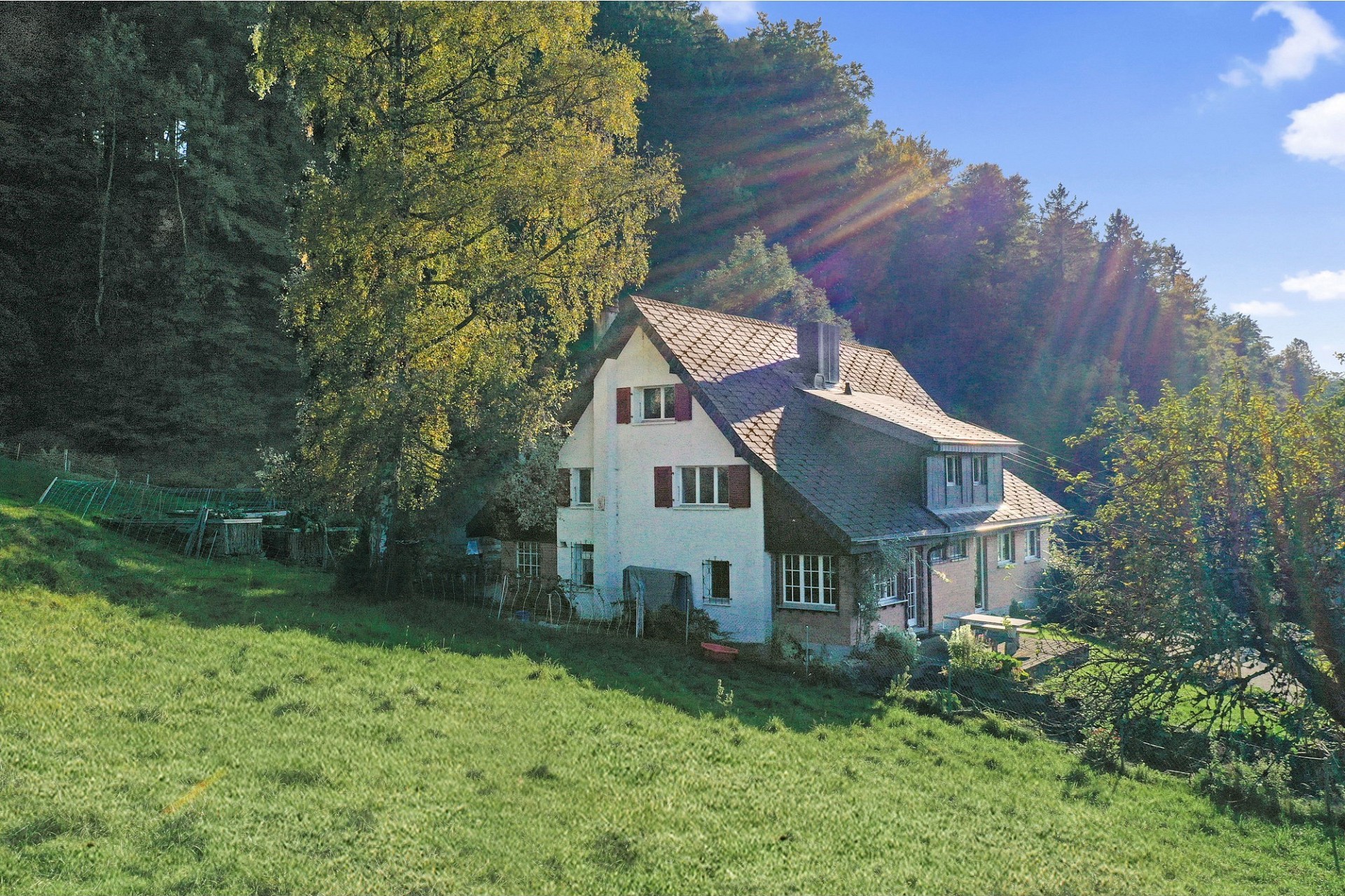 Ländliches Haus am Hang im Sonnenschein