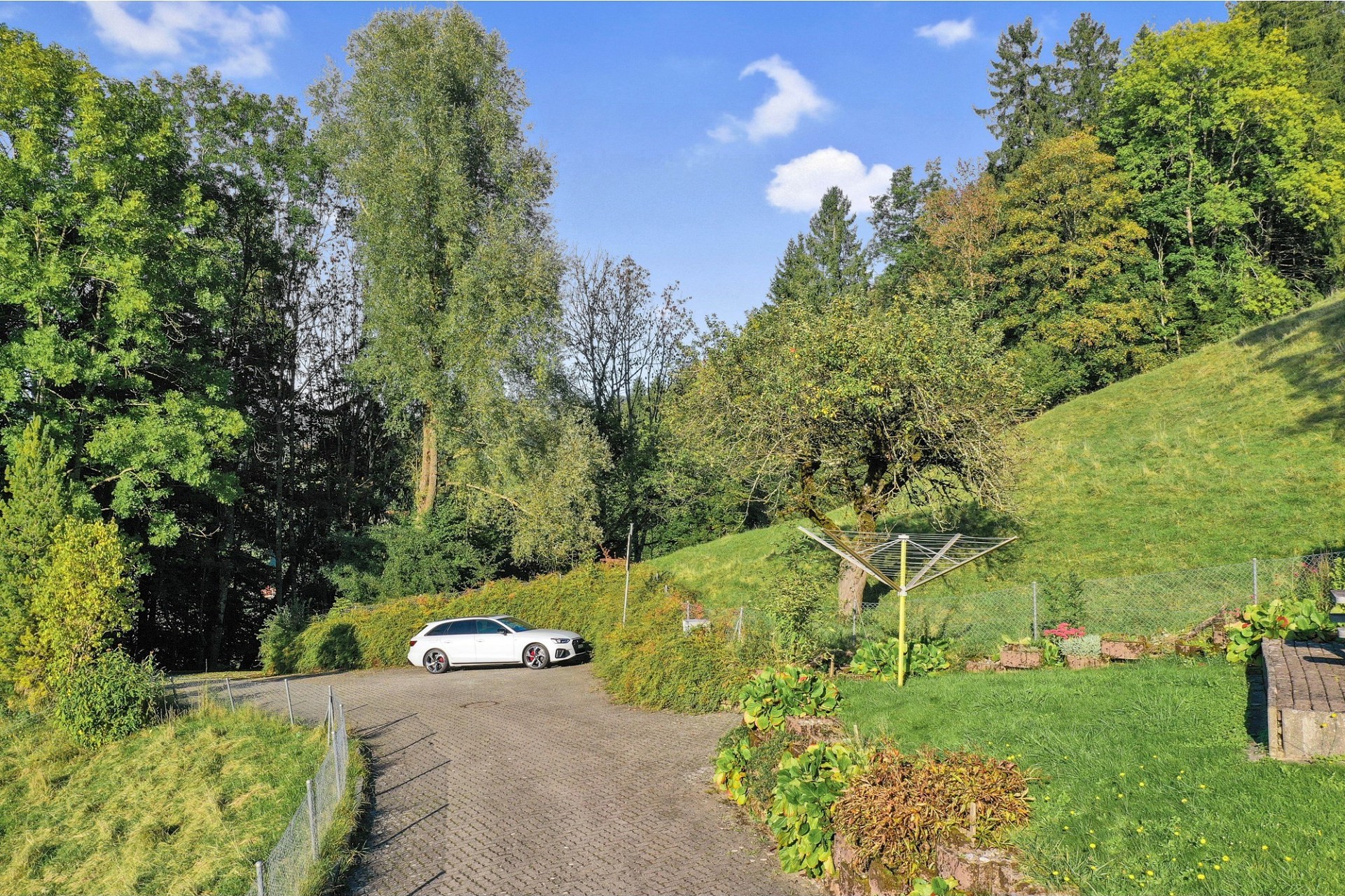 Ländliche Zufahrt mit Parkplatz und großer Grünfläche