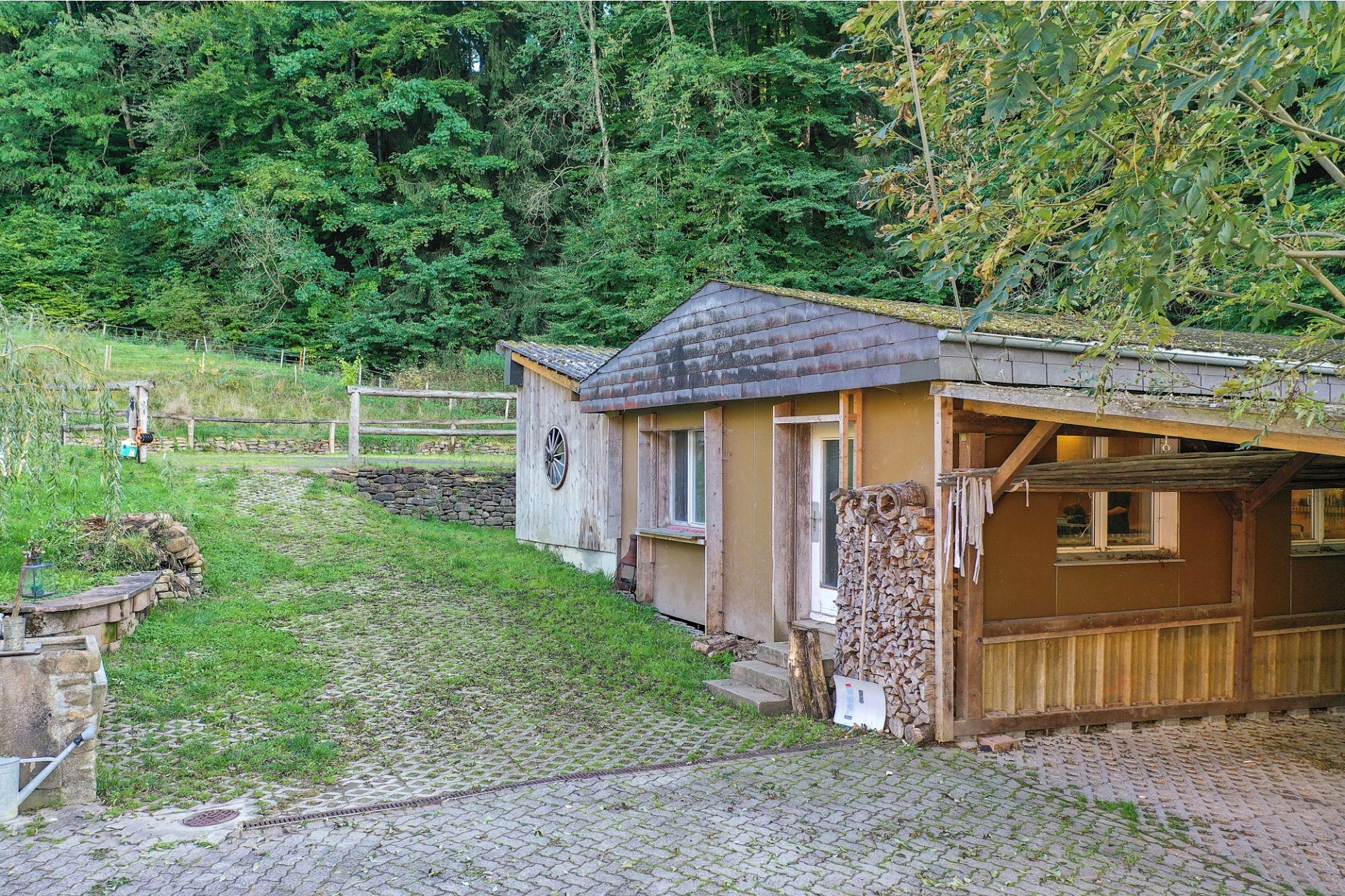 Ländliches Nebengebäude mit Holzverkleidung und Innenhof