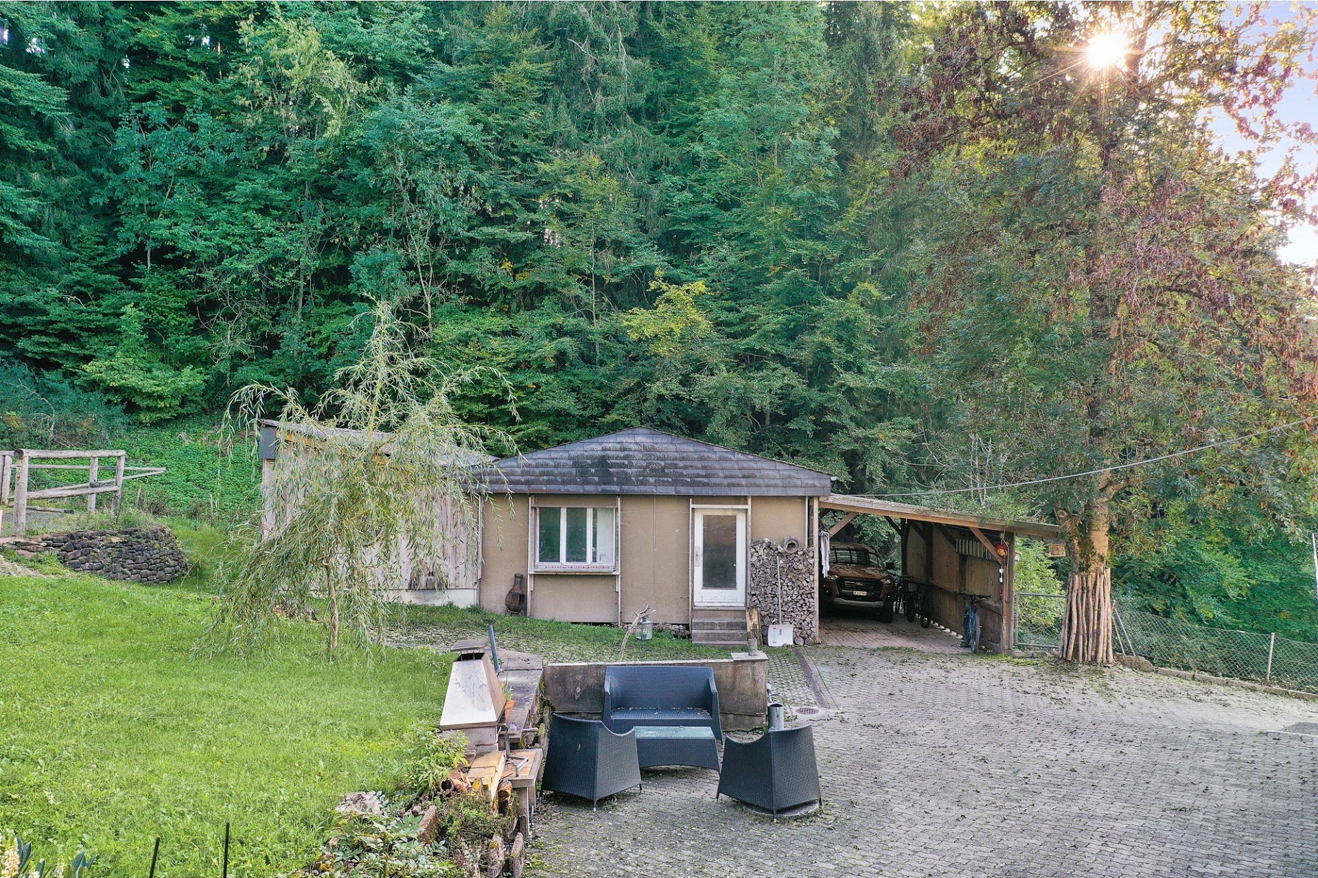 Ländliches Nebengebäude mit Carport und Sitzbereich