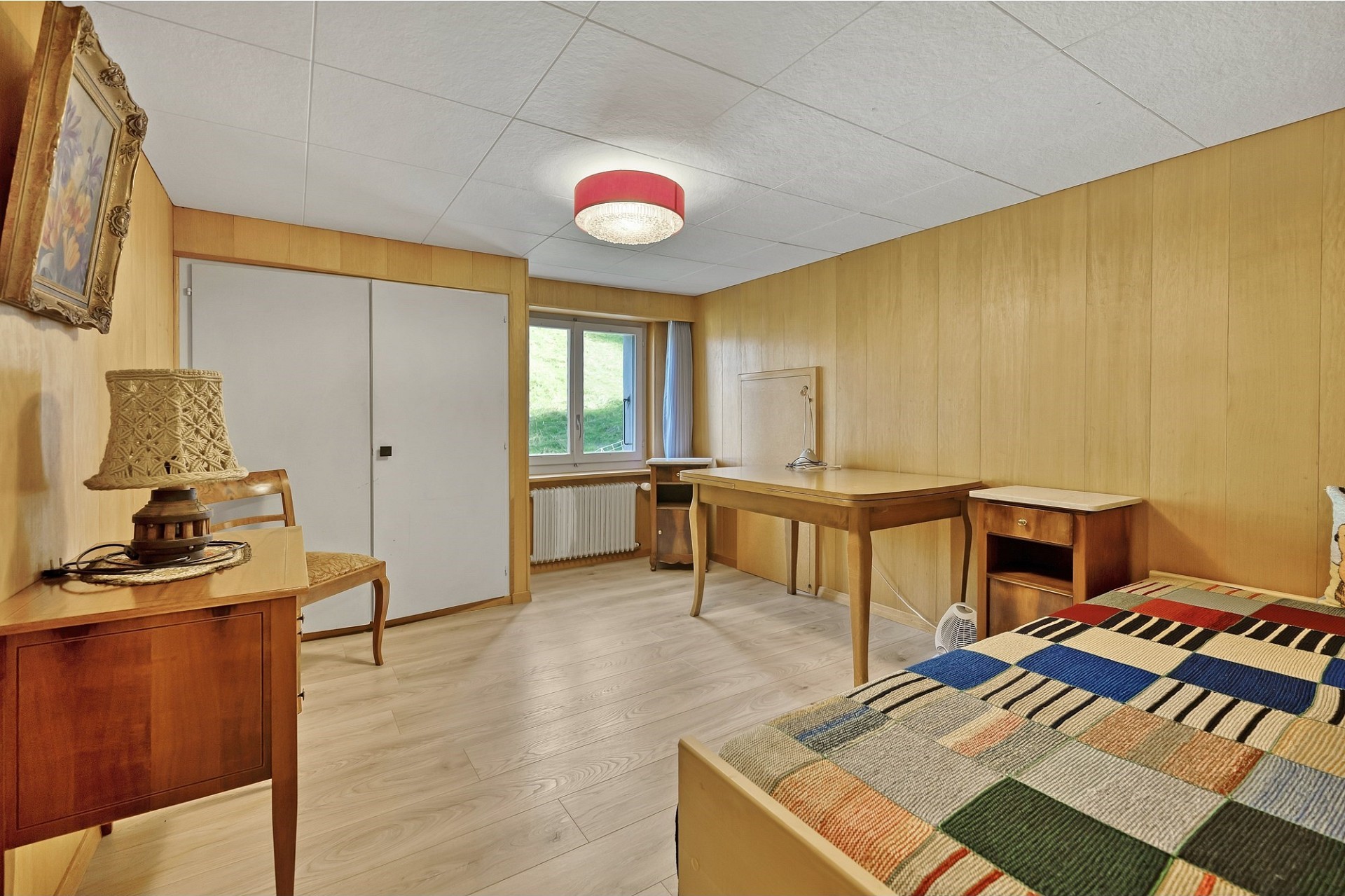 Schlichtes Schlafzimmer mit Holzvertäfelung