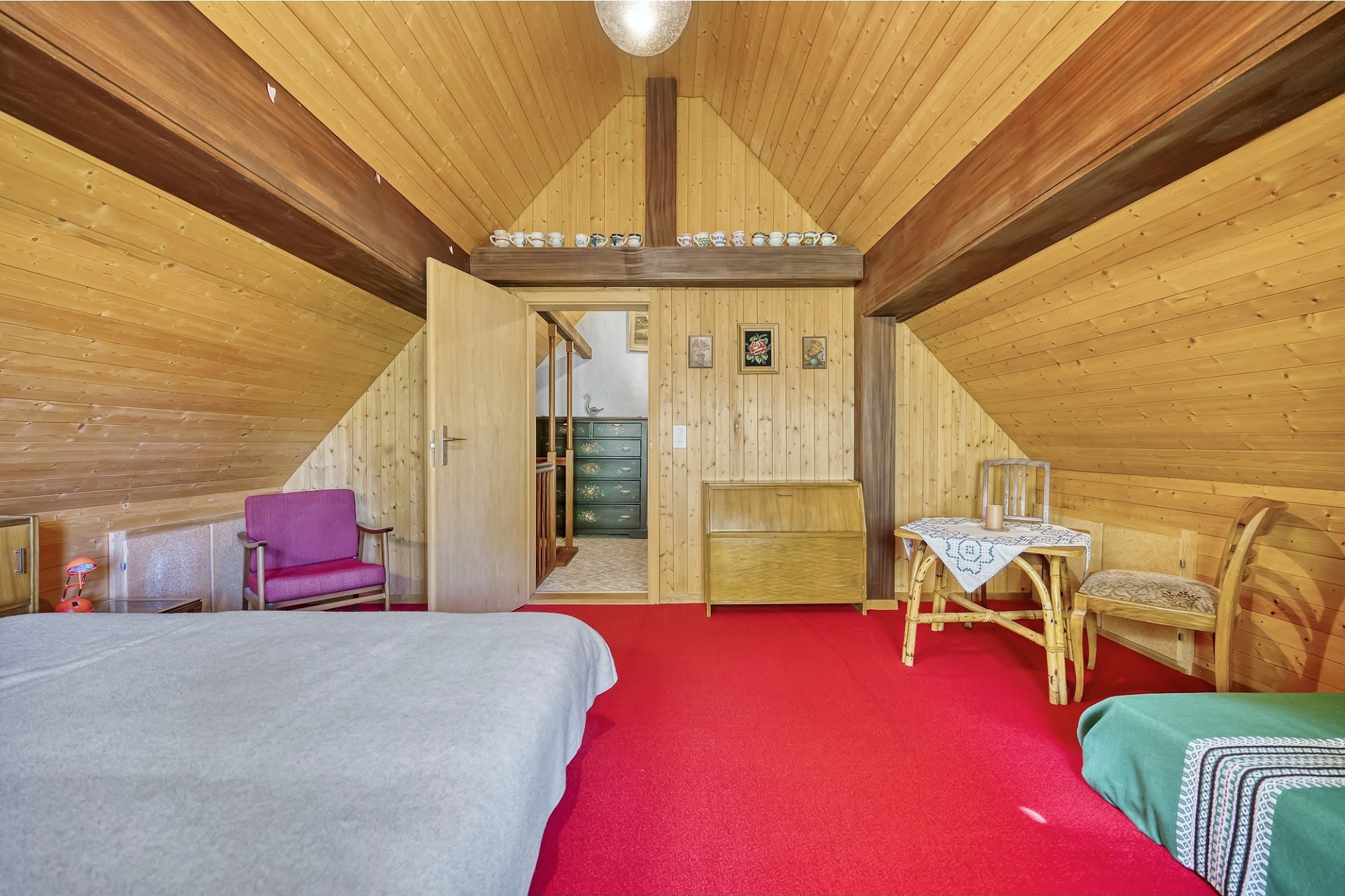 Dachzimmer mit Holzverkleidung und rotem Teppich