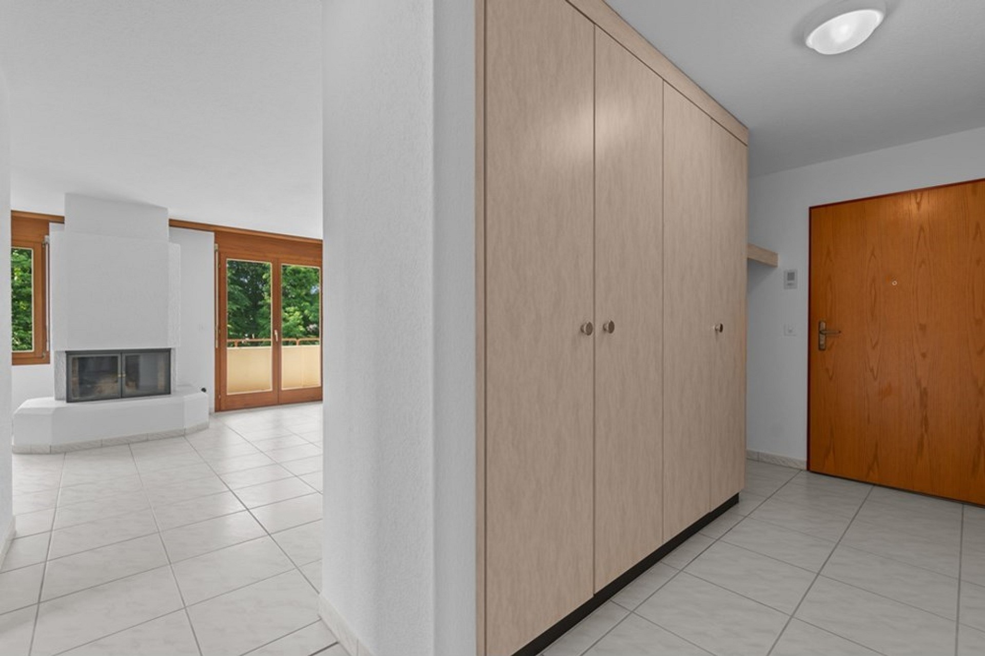 Heller Eingangsbereich mit Kamin und Einbauschrank
