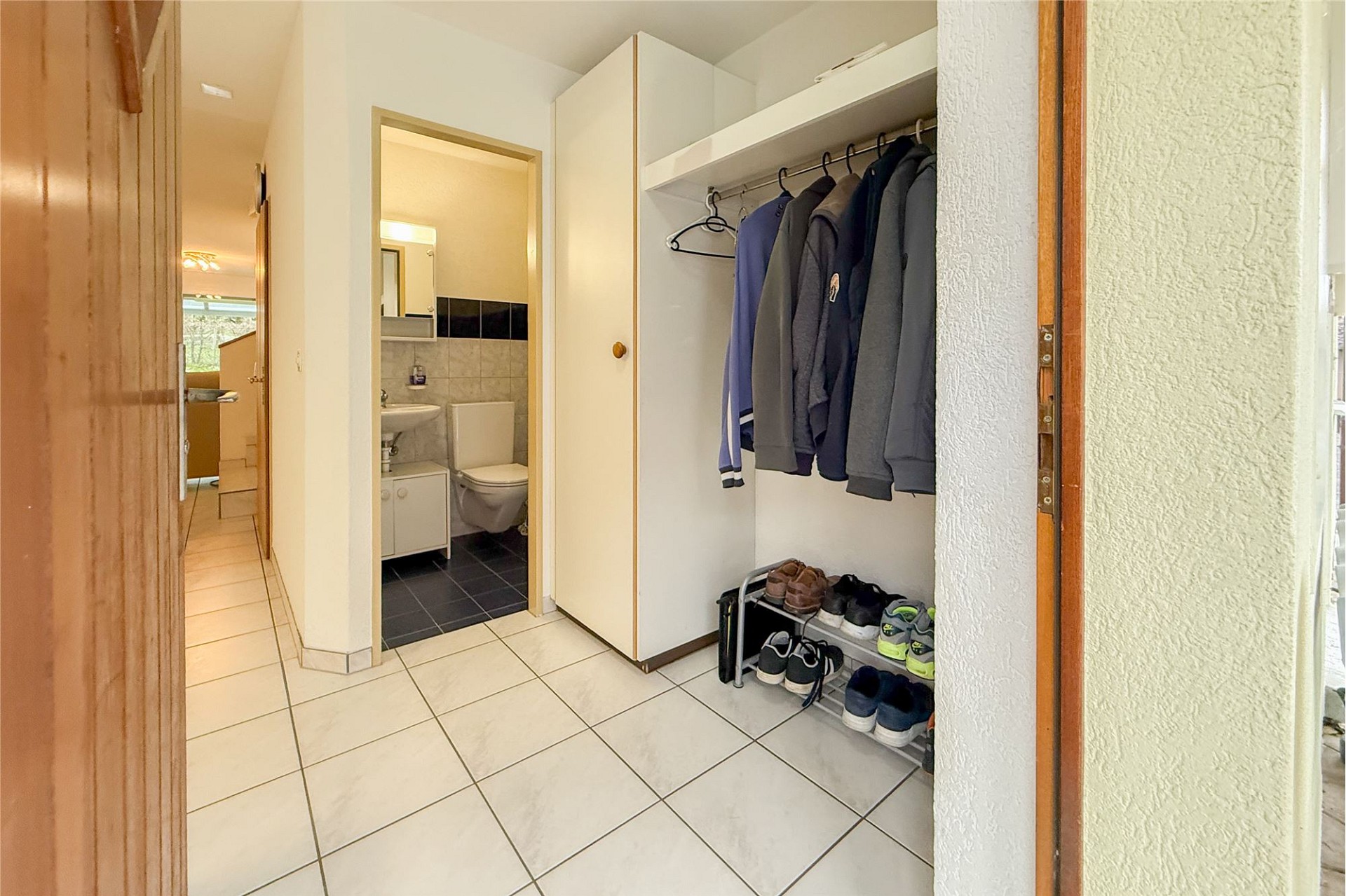 Eingangsbereich mit Garderobe und Blick ins Gäste-WC