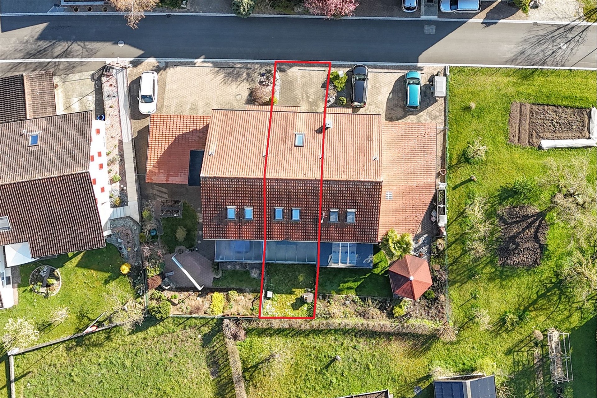 Luftaufnahme eines Einfamilienhauses mit Garten und Einfahrt