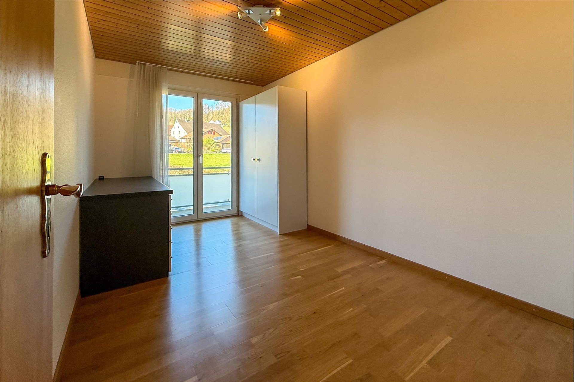 Helles, leeres Zimmer mit Balkonblick