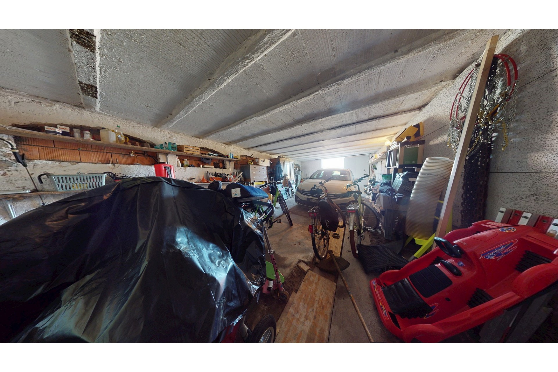 Unordentliche Garage mit Fahrzeugen und Lagergut