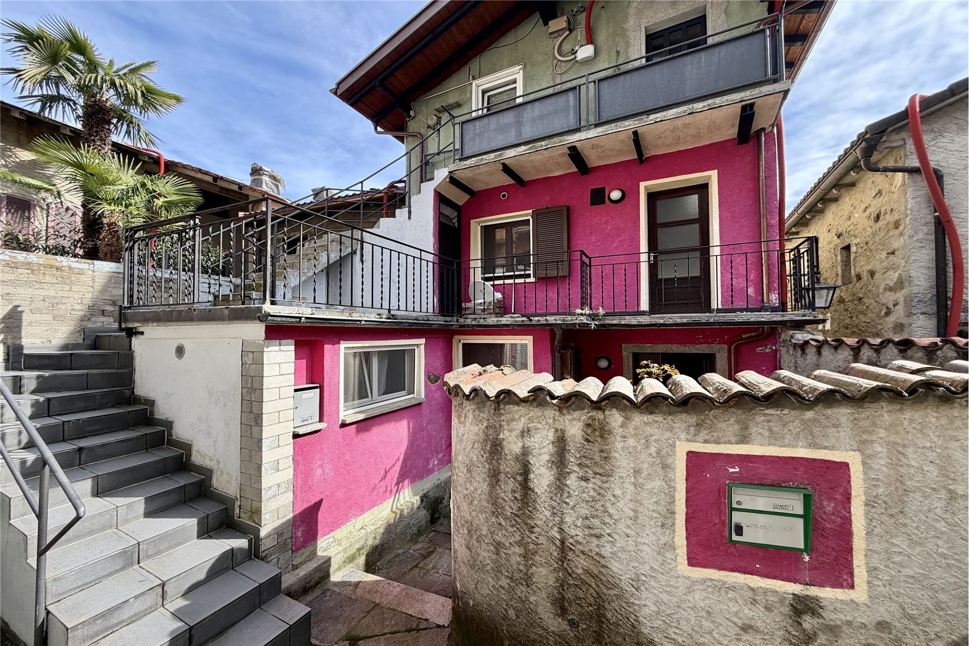 Bunte Außenansicht eines Hauses mit Terrassen, Treppe und Innenhof