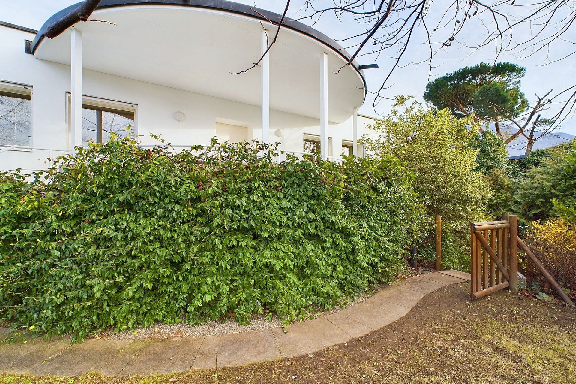 Moderne weiße Hausfassade mit Gartenzugang